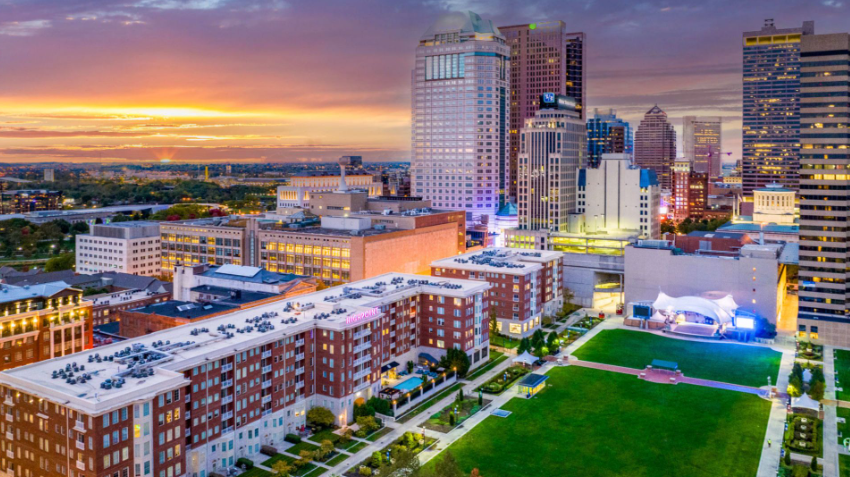 Aerial view of Highpoint on Columbus Commons apartments overlooking Downtown Columbus, Ohio at sunset.