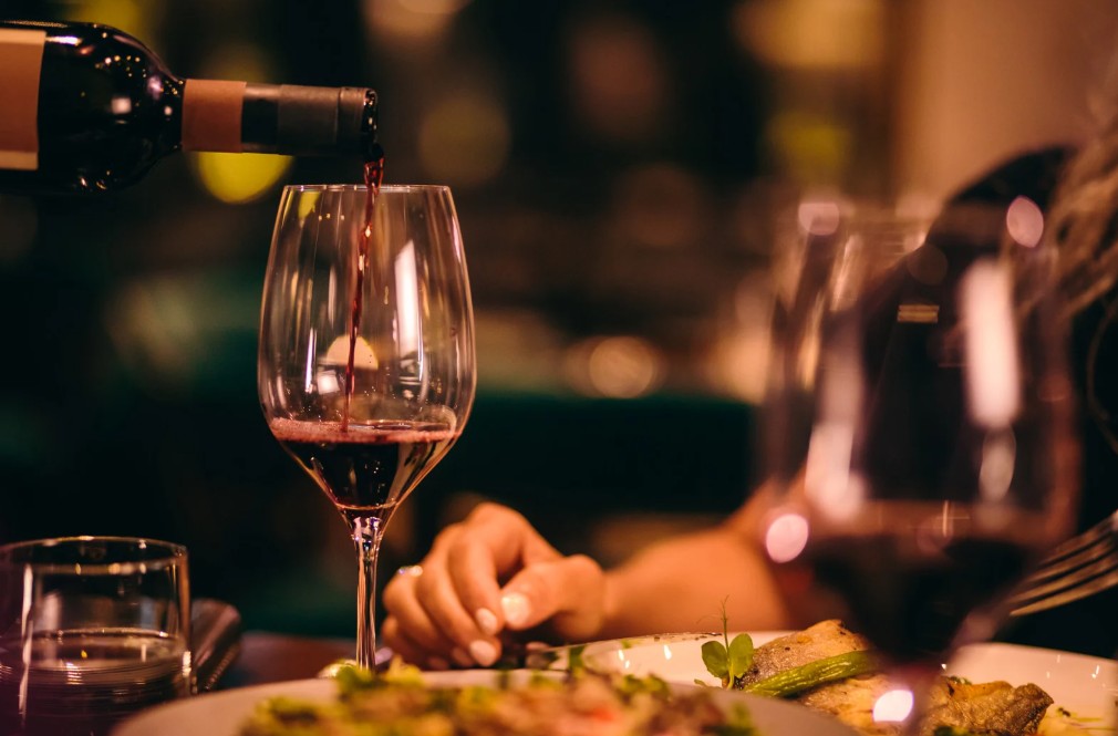 Pouring red wine into a glass at a fine dining restaurant in New Rochelle.
