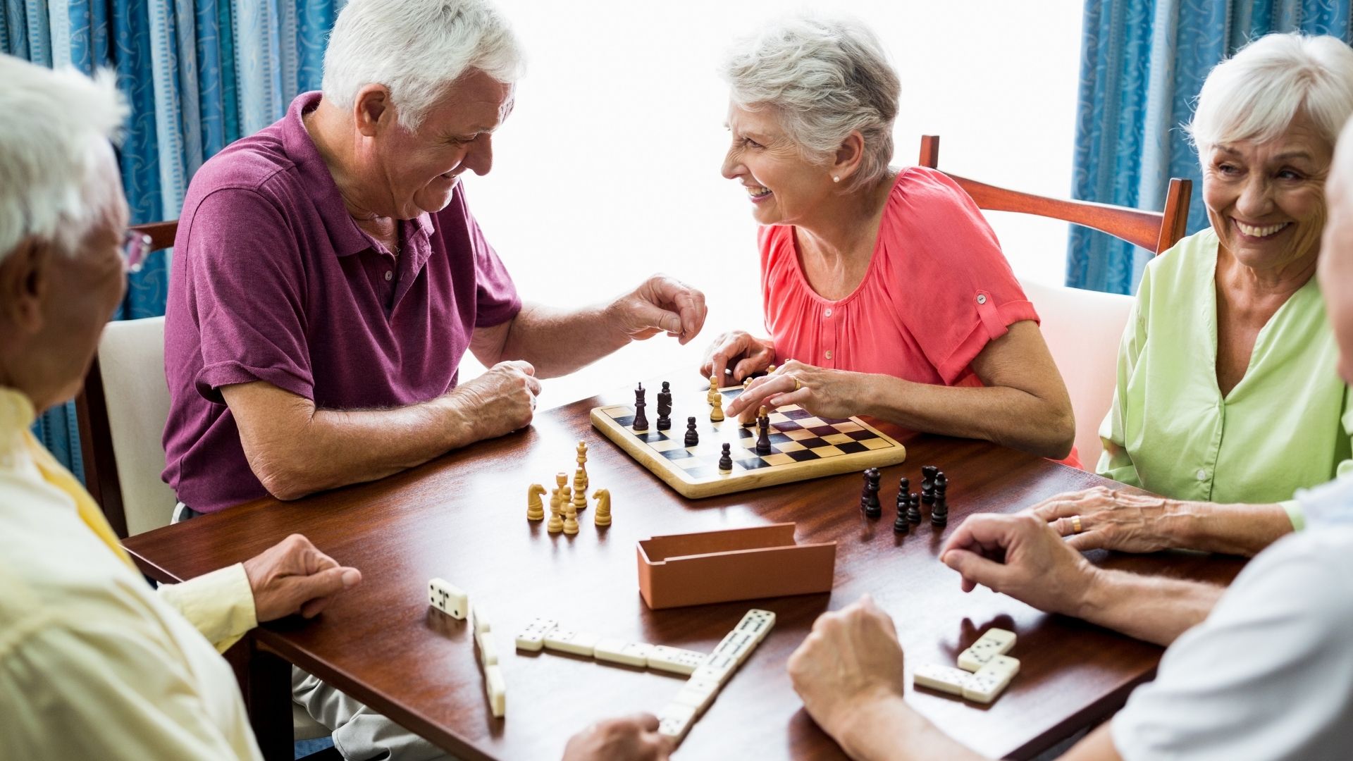 seniors playing chess and dominoes together