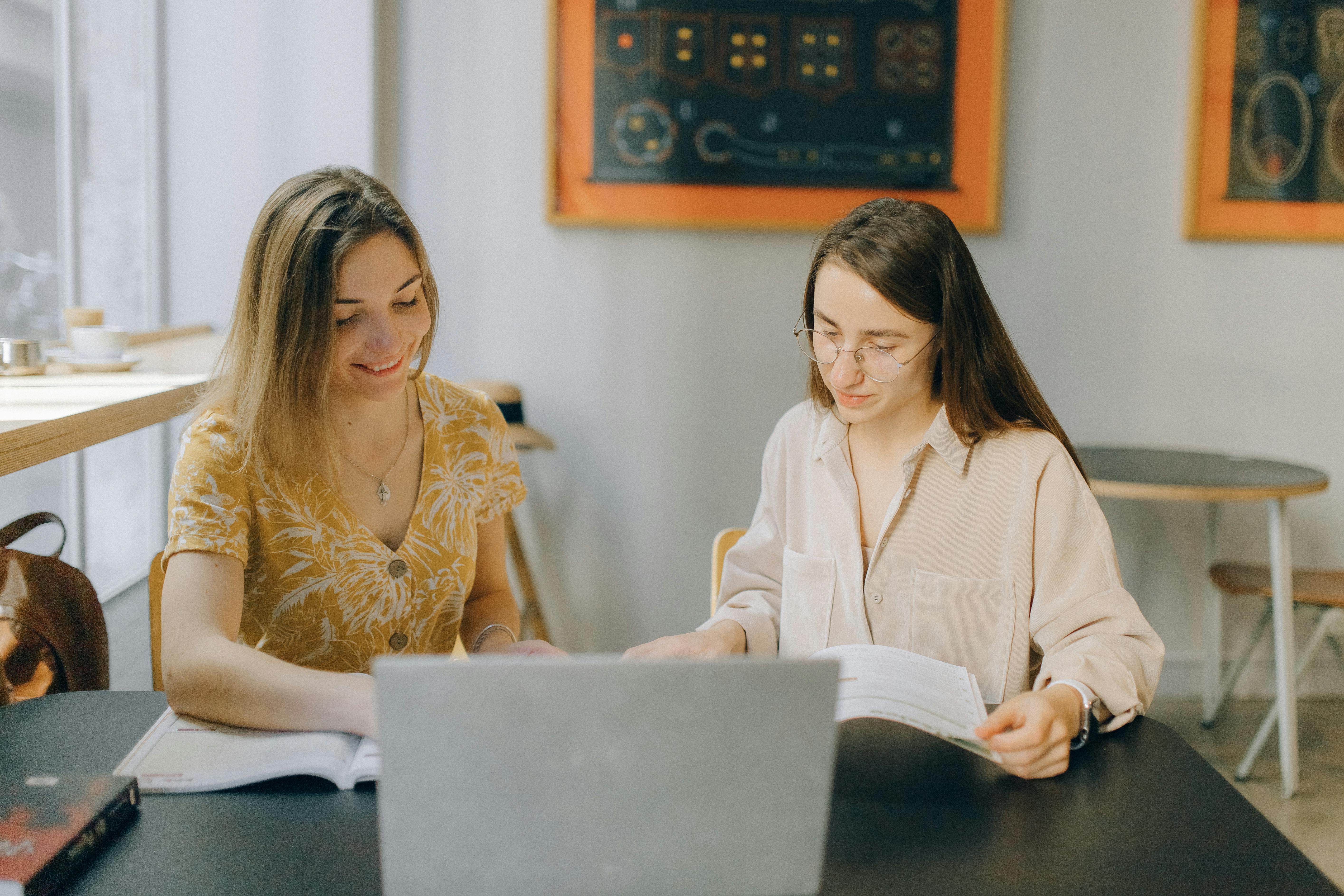 two girls studying in a cozy cafe