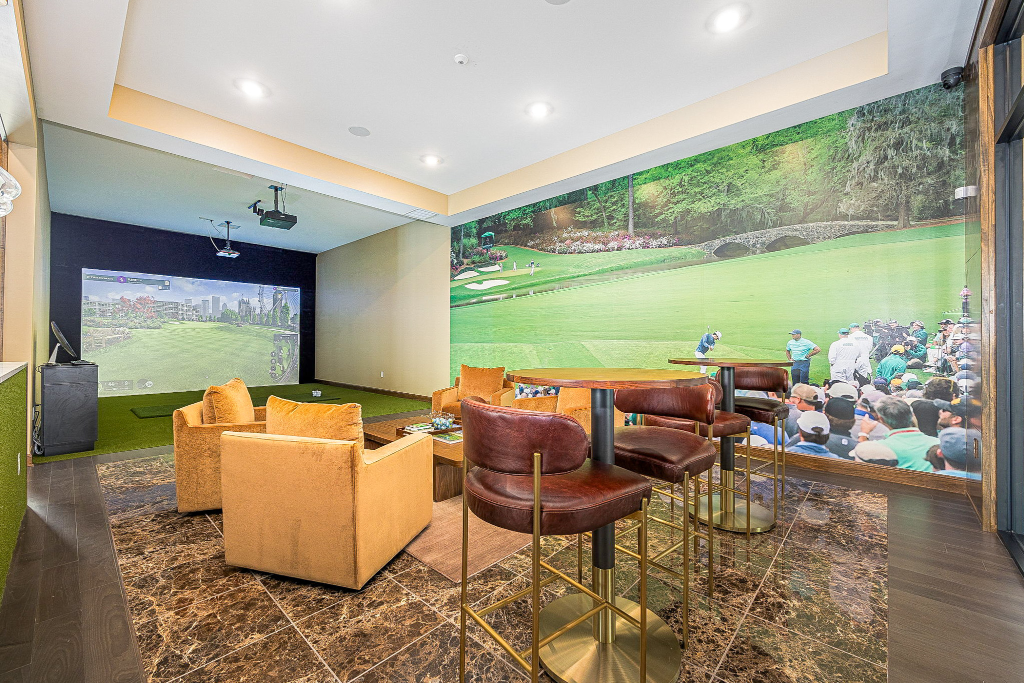TrackMan golf simulator lounge at Club at Woodside apartments in Marysville, Ohio, featuring comfortable seating and a premium indoor golf experience for residents.