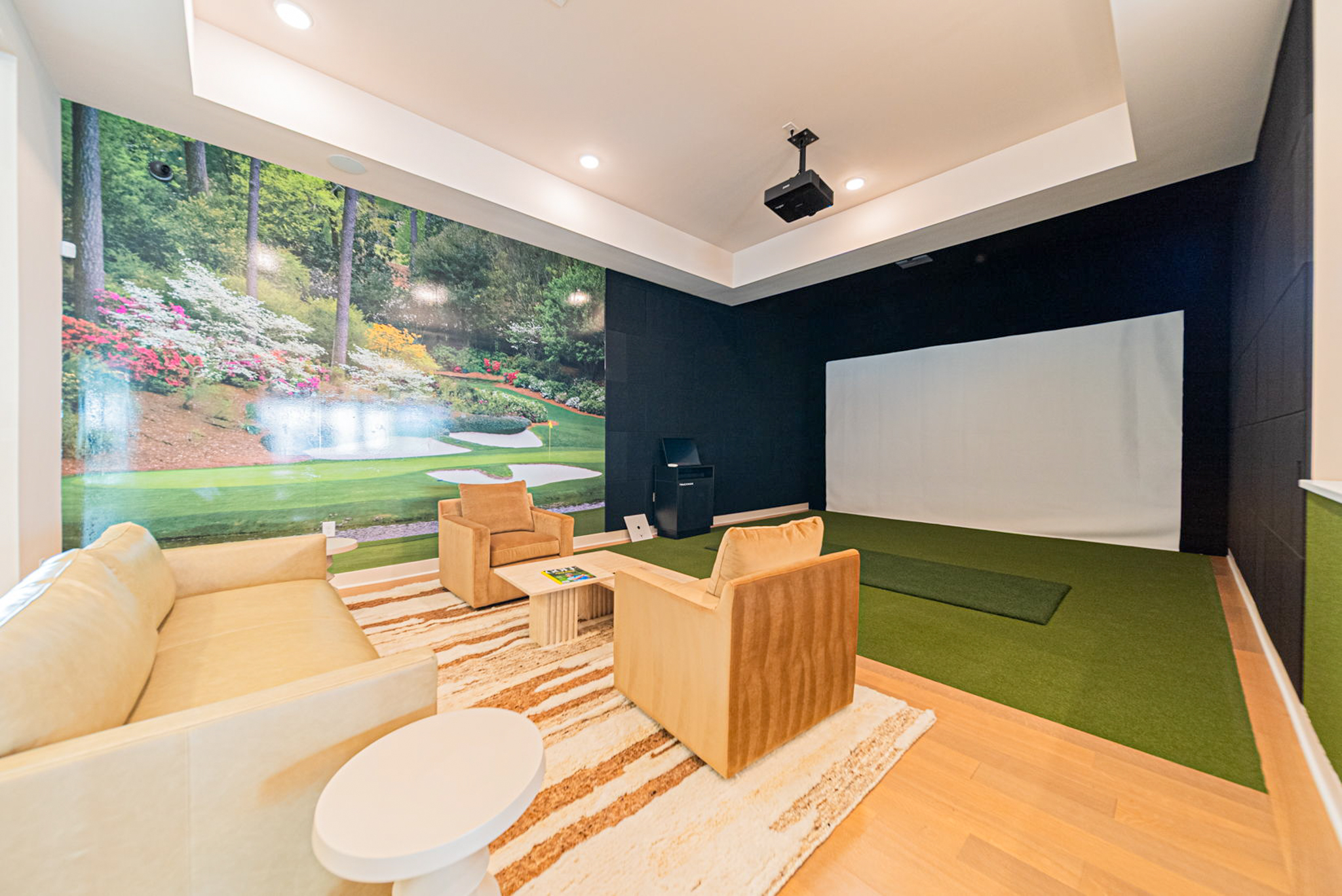 Oxford Park apartments golf simulator room with lounge seating and indoor entertainment amenity in north Columbus Ohio.