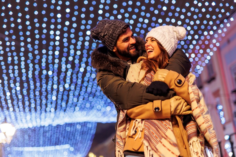 Romantic couple embracing at Asheville NC winter holiday lights festival