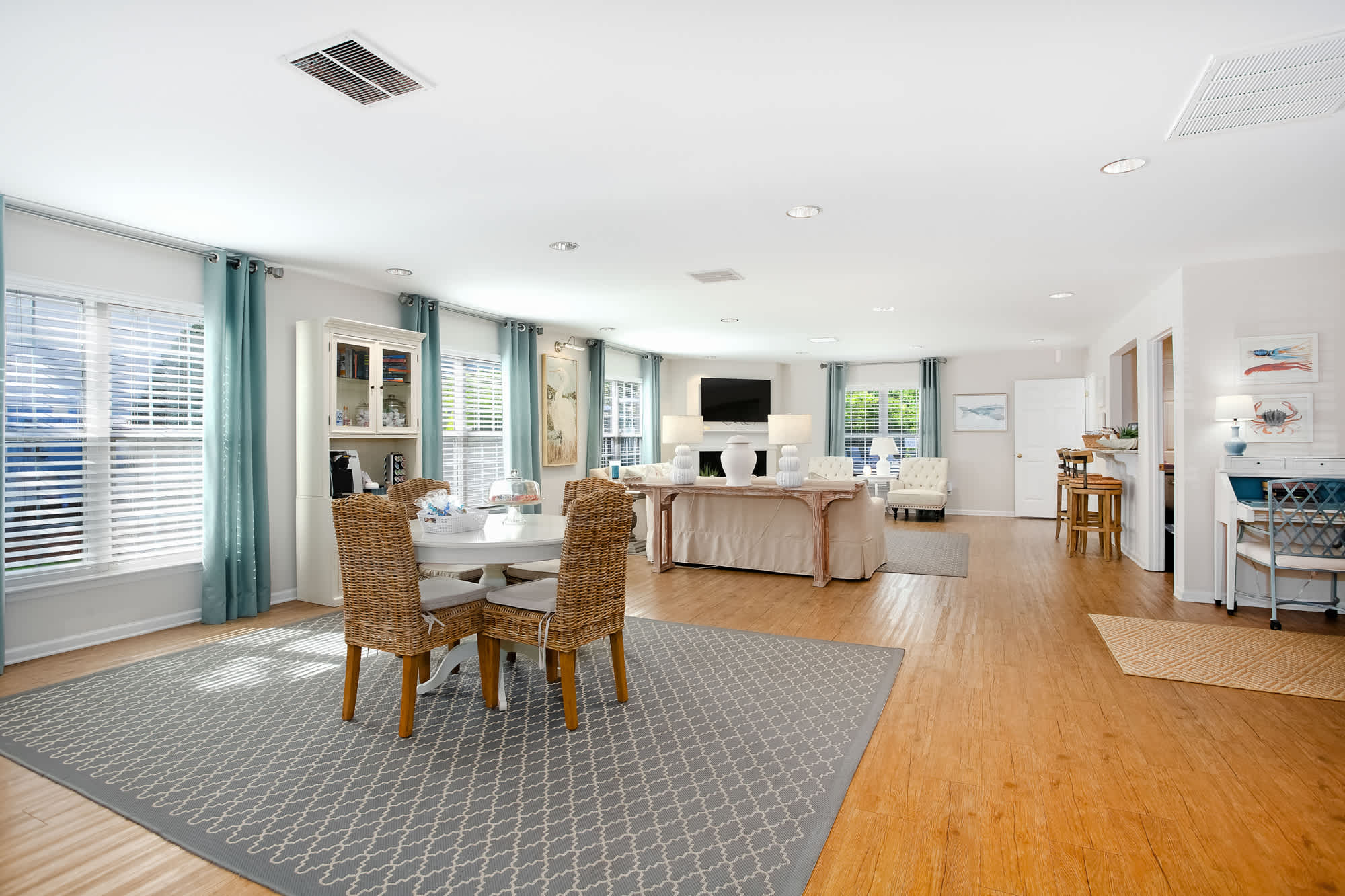 Interior of a Still Meadow Village apartment, showcasing a living room with a dining table and several chairs.