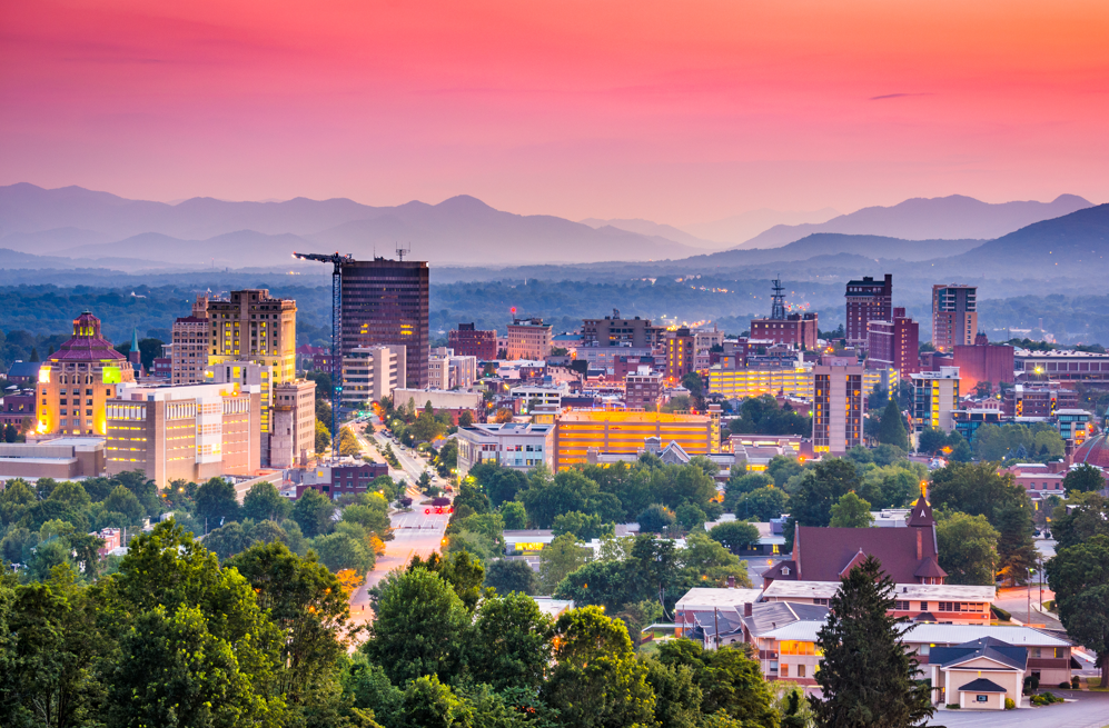 Downtown Asheville NC skyline at sunset with Blue Ridge Mountains in background