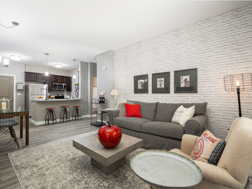 Open-concept living room and kitchen at Landmark Lofts featuring modern finishes, stainless steel appliances, and loft-style design.
