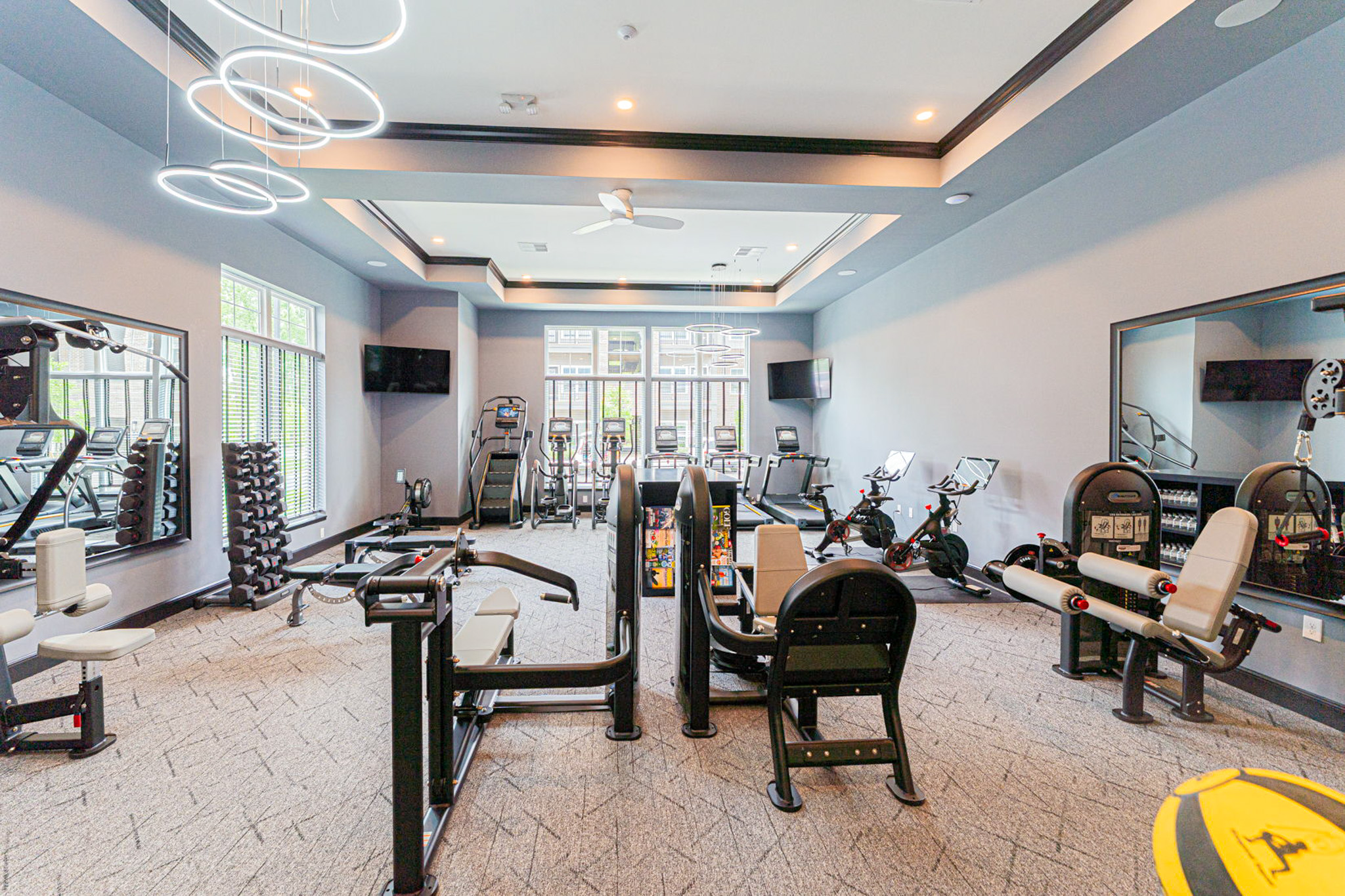 Modern fitness center at Retreat at Citygate in Columbus, Ohio featuring cardio equipment, free weights, strength training machines, Peloton bikes, and floor-to-ceiling windows.
