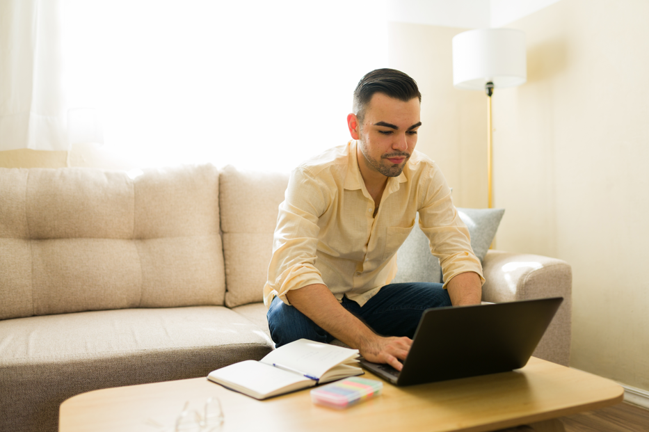 Remote worker using a laptop and notebook in a Foley, Alabama home office.