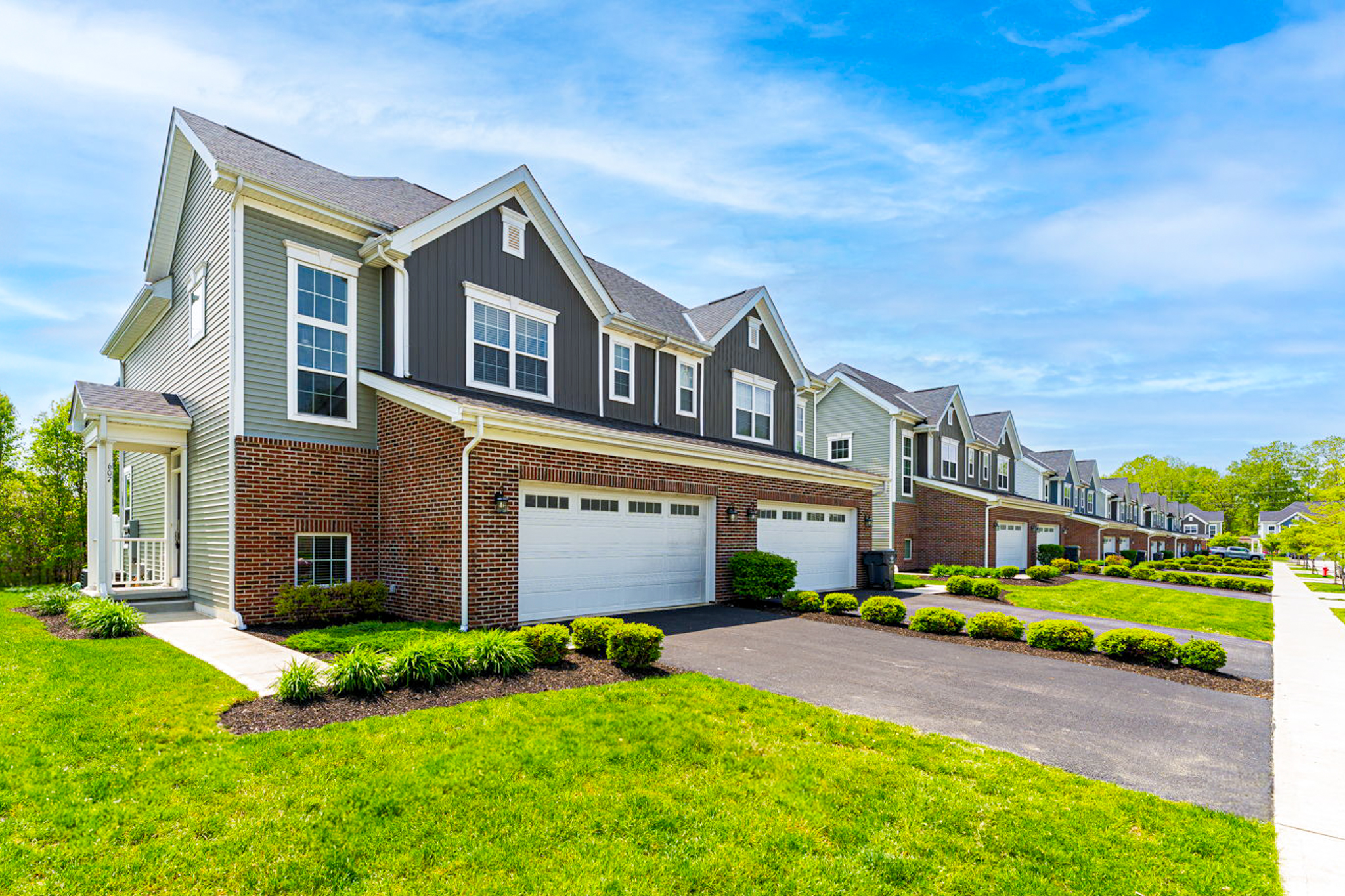 Townhomes at Olentangy Reserve with attached garages and landscaped grounds in Columbus, Ohio.