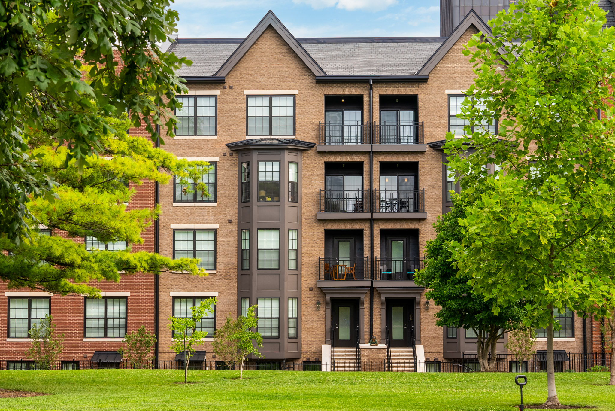 Residences at Topiary Park apartments overlooking Topiary Park in Downtown Columbus, featuring mature trees, walking paths, expansive green space, and a peaceful park-side setting.