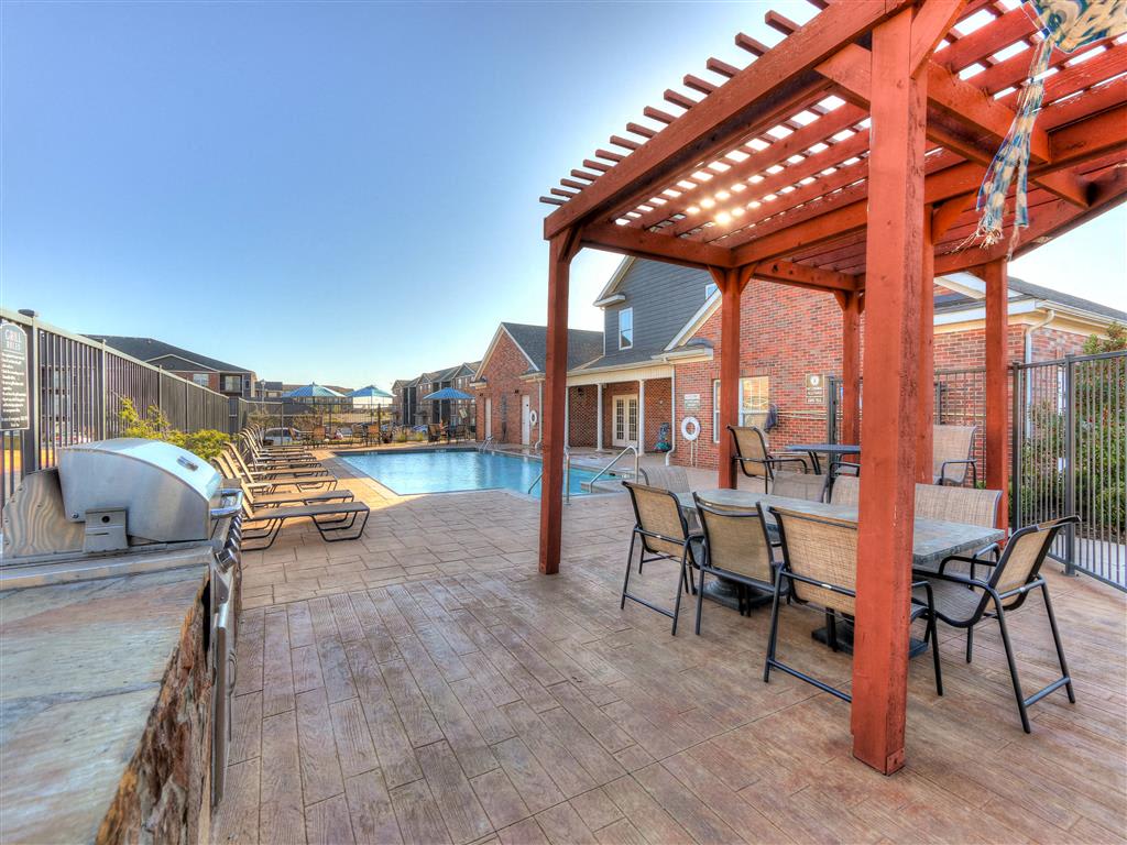 outside deck patio with barbeque grill and in-ground swimming pool at The Residence at North Penn Apartment Homes in Oklahoma City