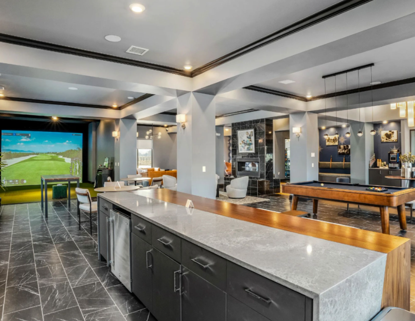 Resident clubhouse with golf simulator and lounge space at Northstar Flats apartments in Sunbury, Ohio.
