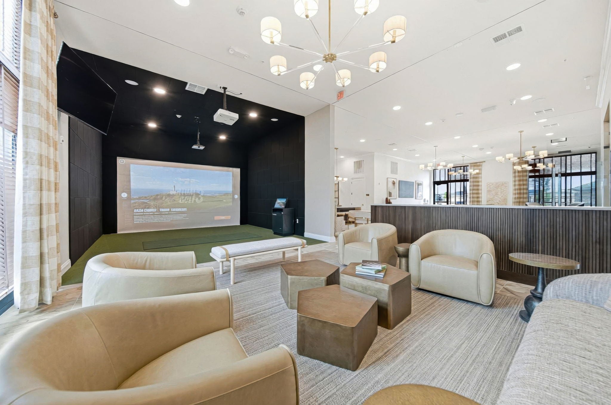 Golf simulator lounge and resident clubhouse at Lawrence Square Apartments in Columbus, Ohio, featuring comfortable seating, upscale finishes, coworking space, and premium community amenities near Dublin and Hilliard.