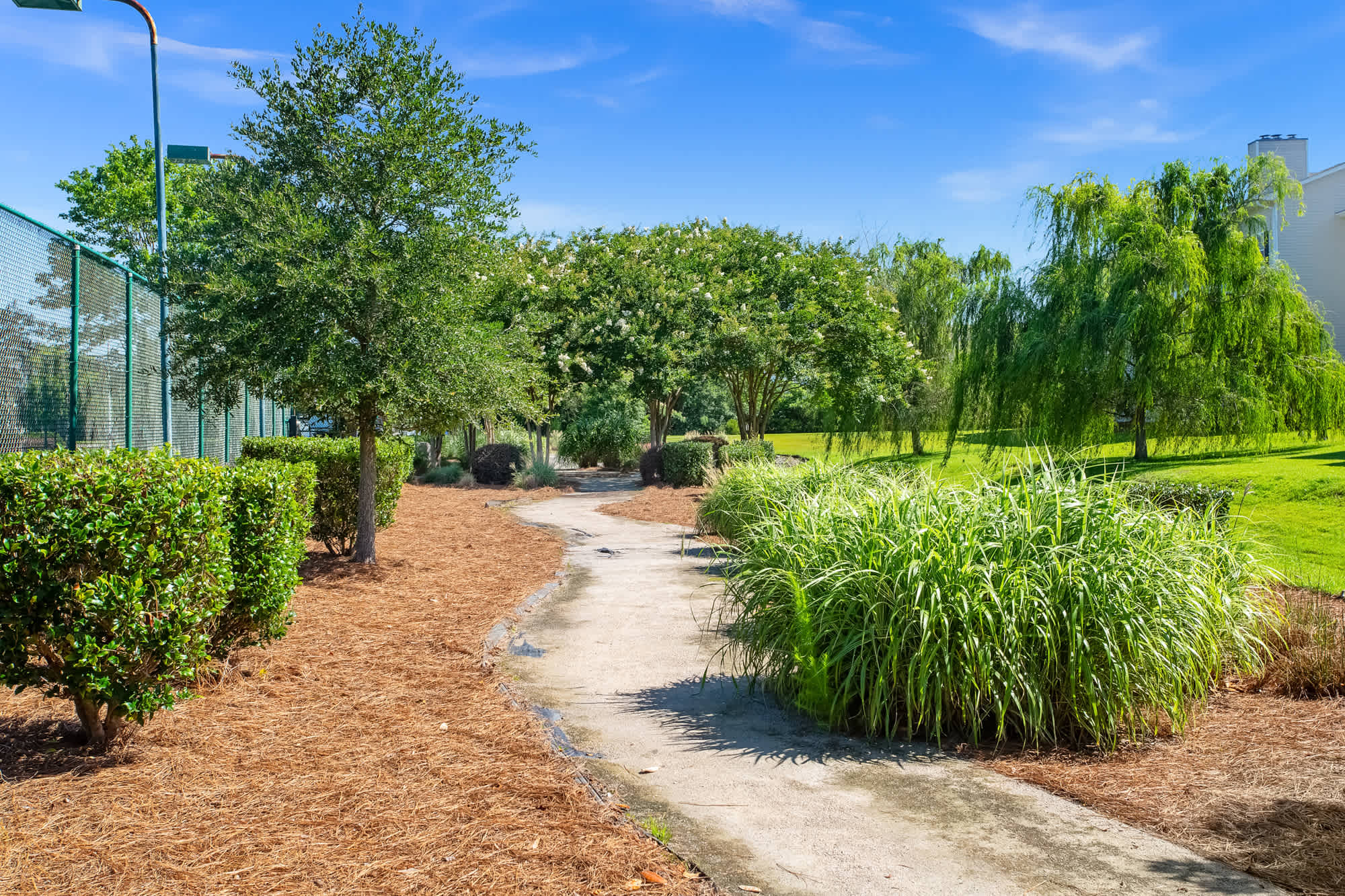 Entrance to Still Meadow Village apartments in Wilmington, NC, featuring welcoming architecture and landscaped surroundings.