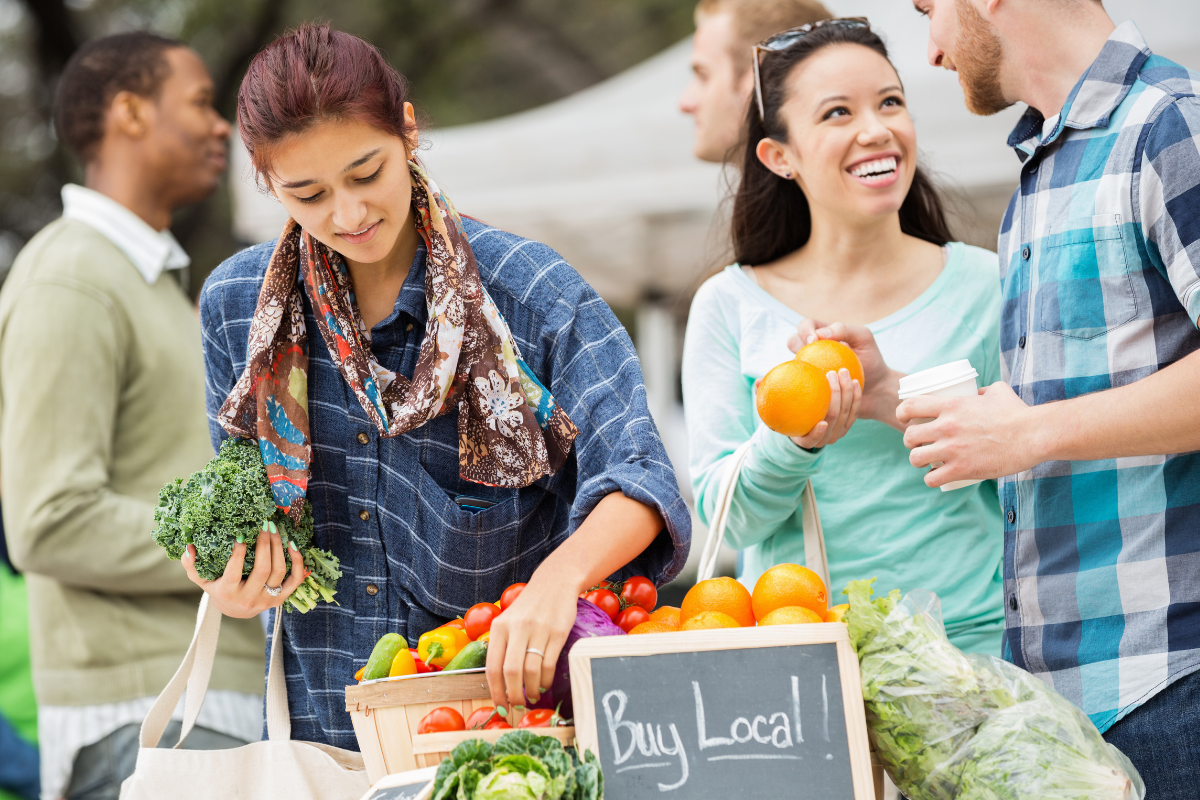 People shopping at a local farmers market, highlighting fresh food and community events in Dayton, Ohio.