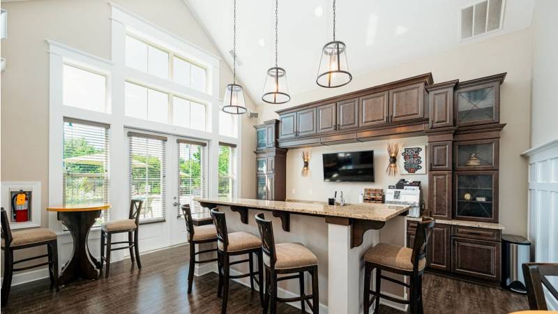Elegant clubhouse interior at Ravines at Westar apartments in Polaris Ohio featuring vaulted wood-beam ceilings, a stone fireplace, and comfortable seating areas.