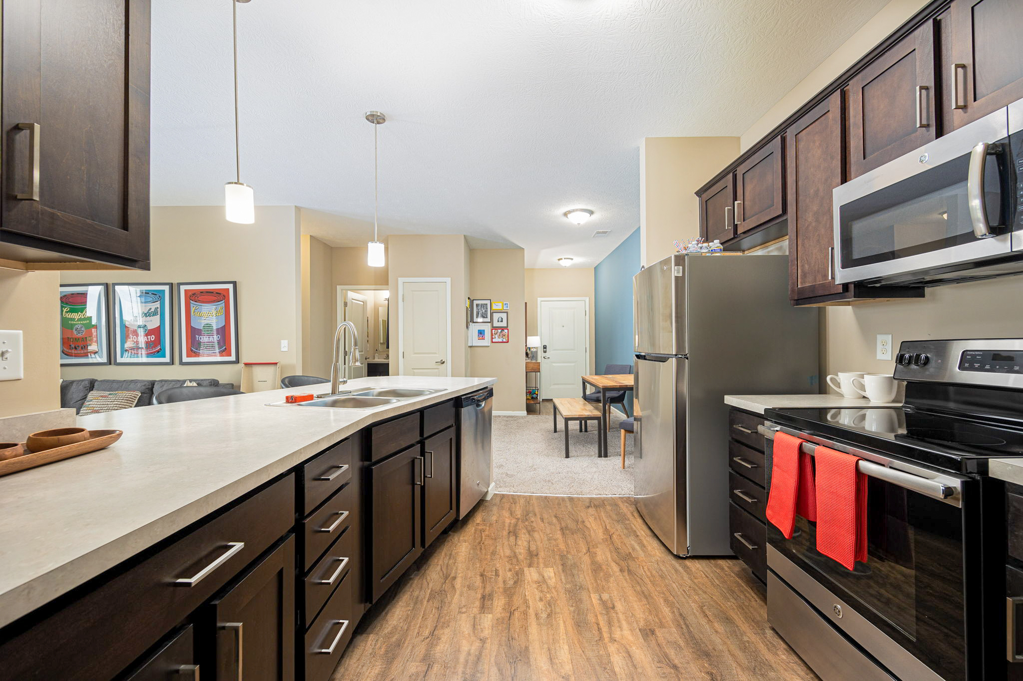 Modern apartment kitchen at The Wendell with stainless steel appliances and island seating.