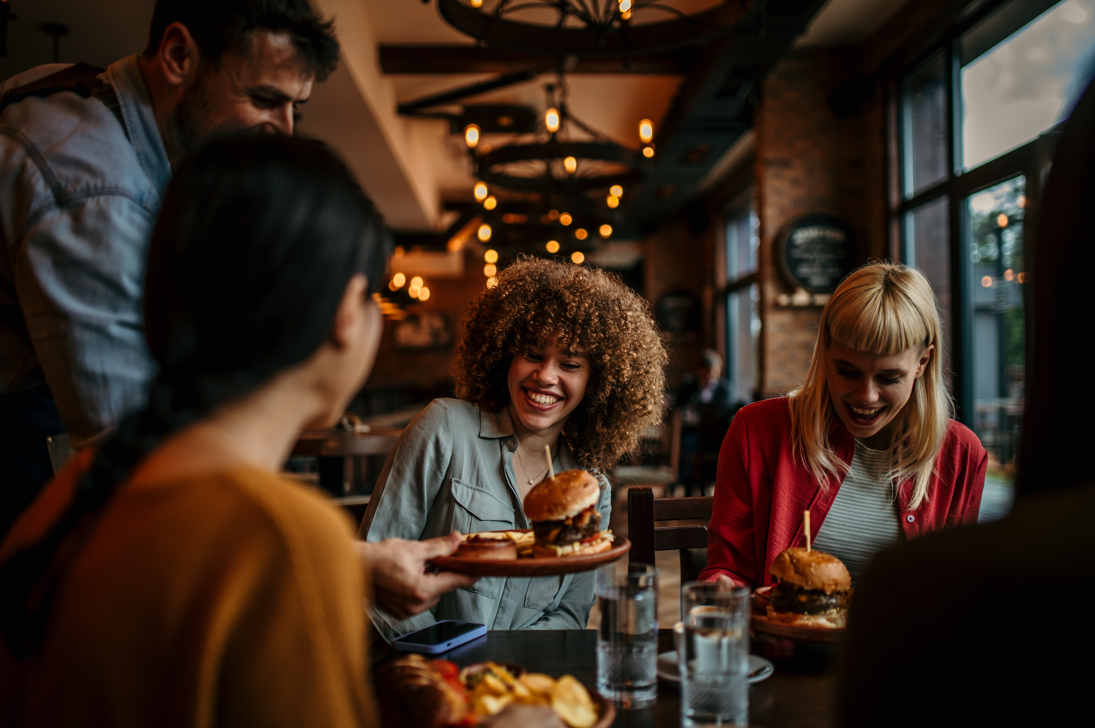 Friends enjoying burgers and drinks at a lively restaurant in the Fairmount neighborhood of Philadelphia.