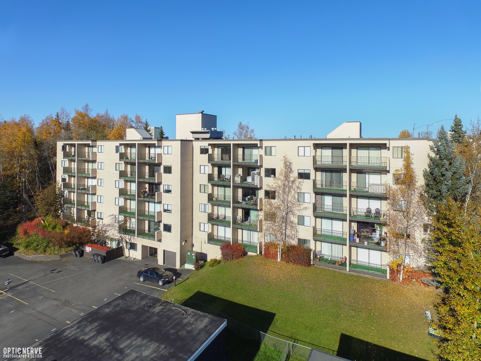 view of multistory apartment with open parking, plants at The Outlook Apartments  in Anchorage, AK