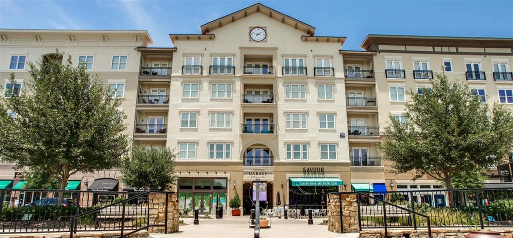 The outside entrance of the multi-story apartment complex, The Lofts at Watters Creek in Allen, TX, owned by Weidner Apartment Homes.