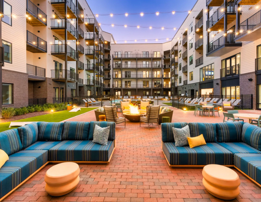 Outdoor courtyard at Galaxy at Polaris located on Polaris Parkway featuring a resort-style swimming pool, fire pit, lounge seating, and string lights.