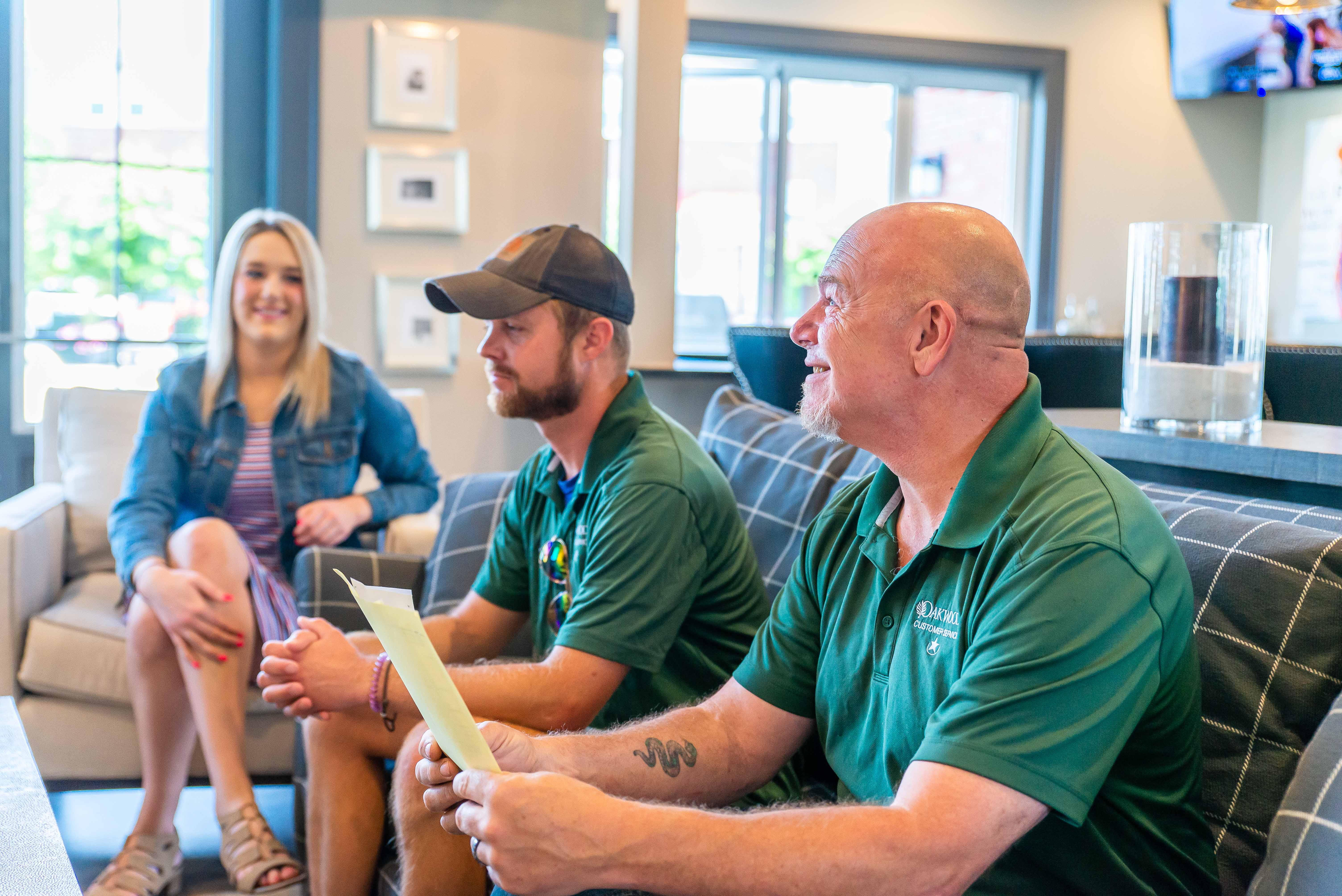 Oakwood Management employees reviewing documents and talking together in an apartment community clubhouse in Columbus, Ohio.