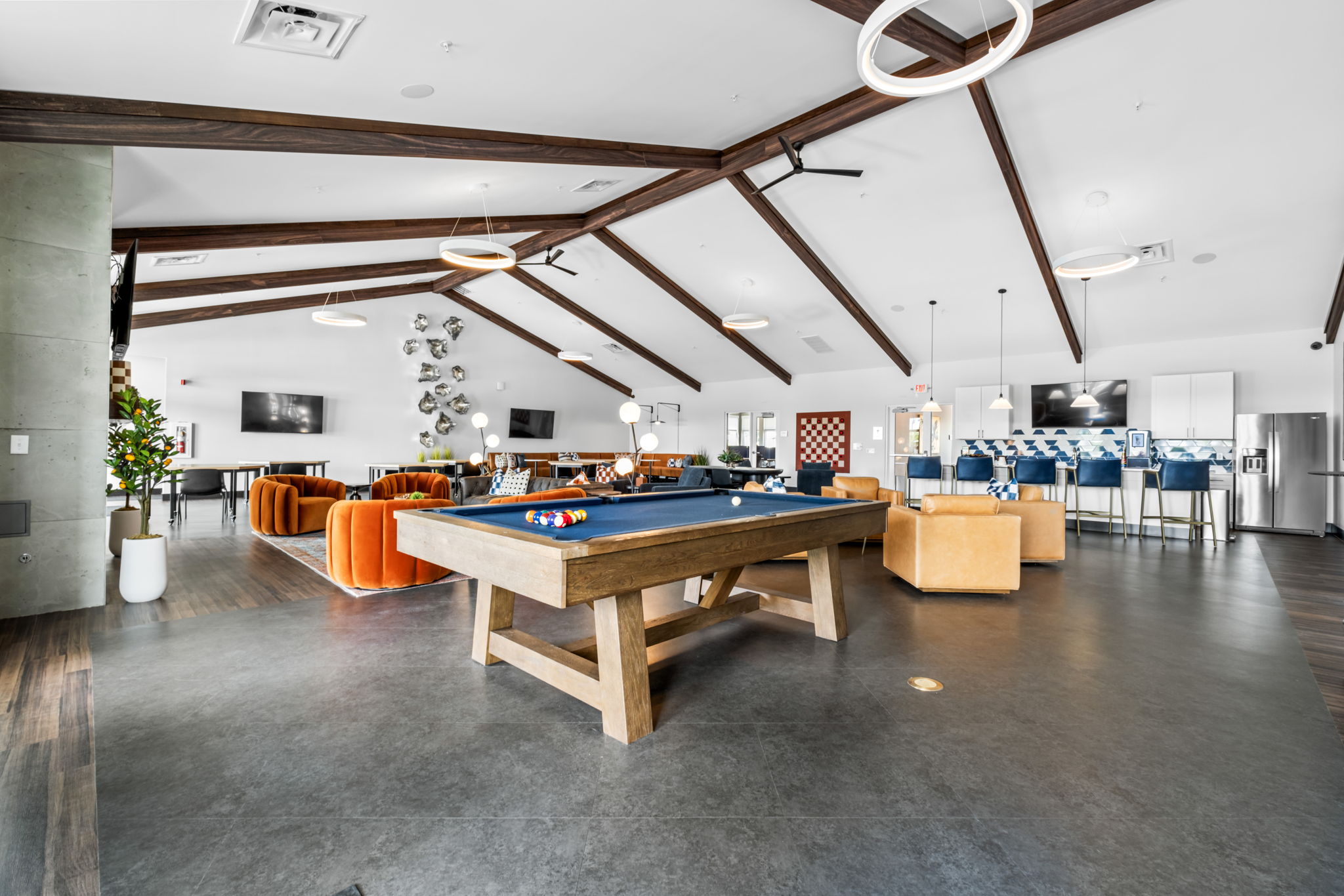 Modern clubhouse at The Zelle at Polaris featuring billiards table, seating areas, and community lounge space.