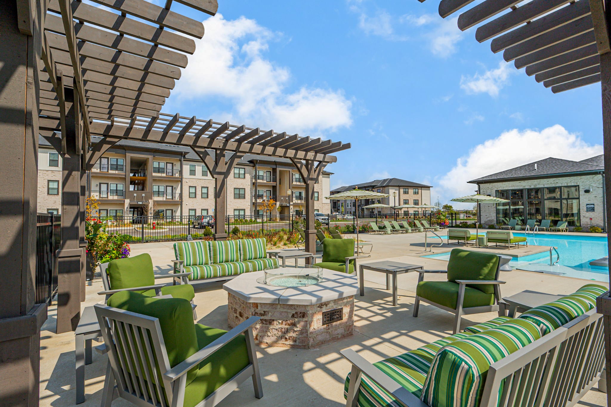 Outdoor patio and seating area with fire pit at The Club at Woodside apartments in Marysville, Ohio near the pool and community amenities.