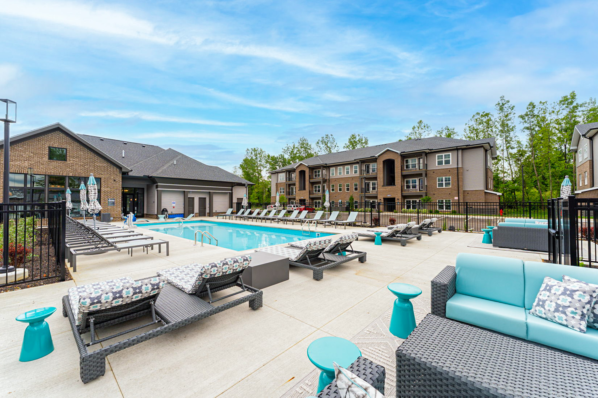 Resort-style swimming pool and sundeck at Retreat at CityGate apartment community in Columbus, Ohio, featuring modern apartment buildings, lounge seating, and upscale outdoor amenities.