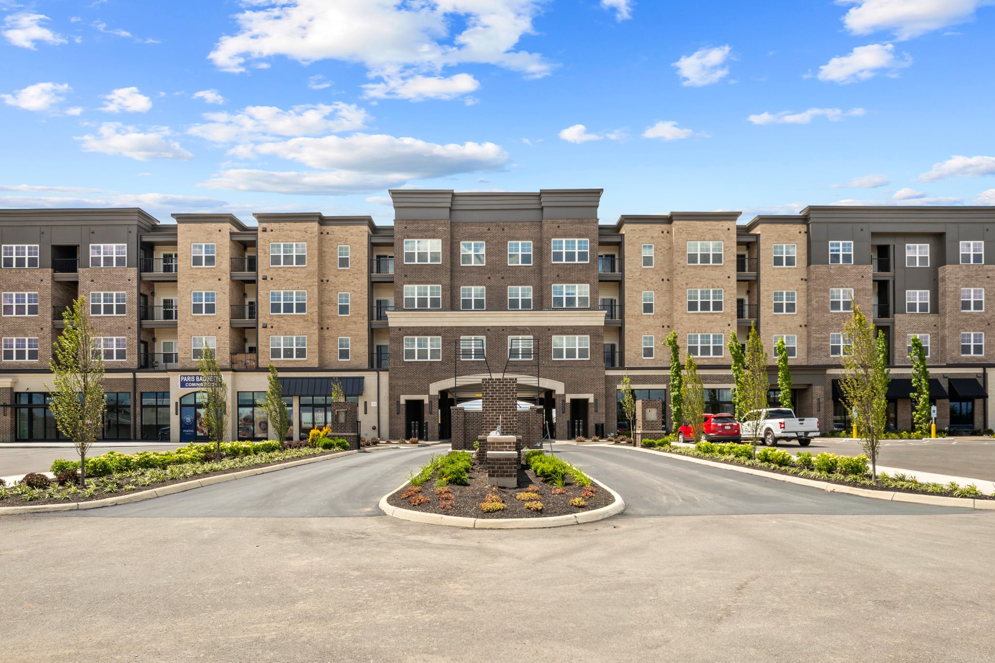 Exterior of Lawrence Square Apartments in Columbus, Ohio, featuring modern architecture, a landscaped entryway, upscale apartment homes, and convenient access to Dublin and Hilliard.