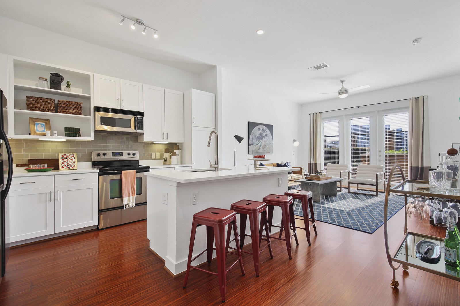 interior kitchen with oven, shelves, island, stools and microwave at the Uptown Apartment Homes in Dallas Texas