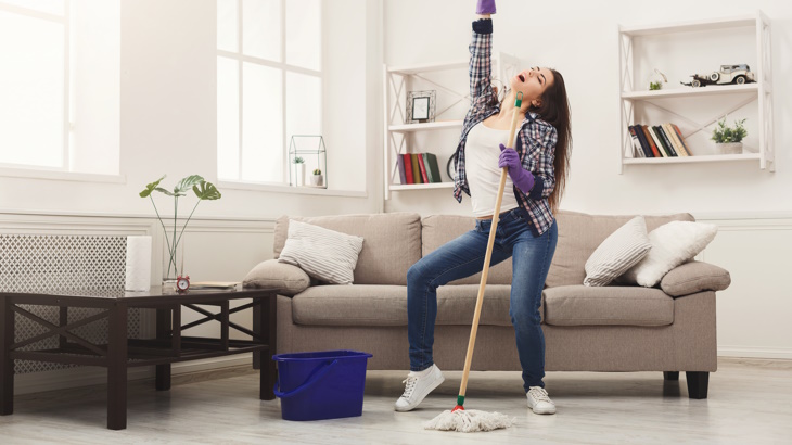woman dancing with a mop while cleaning