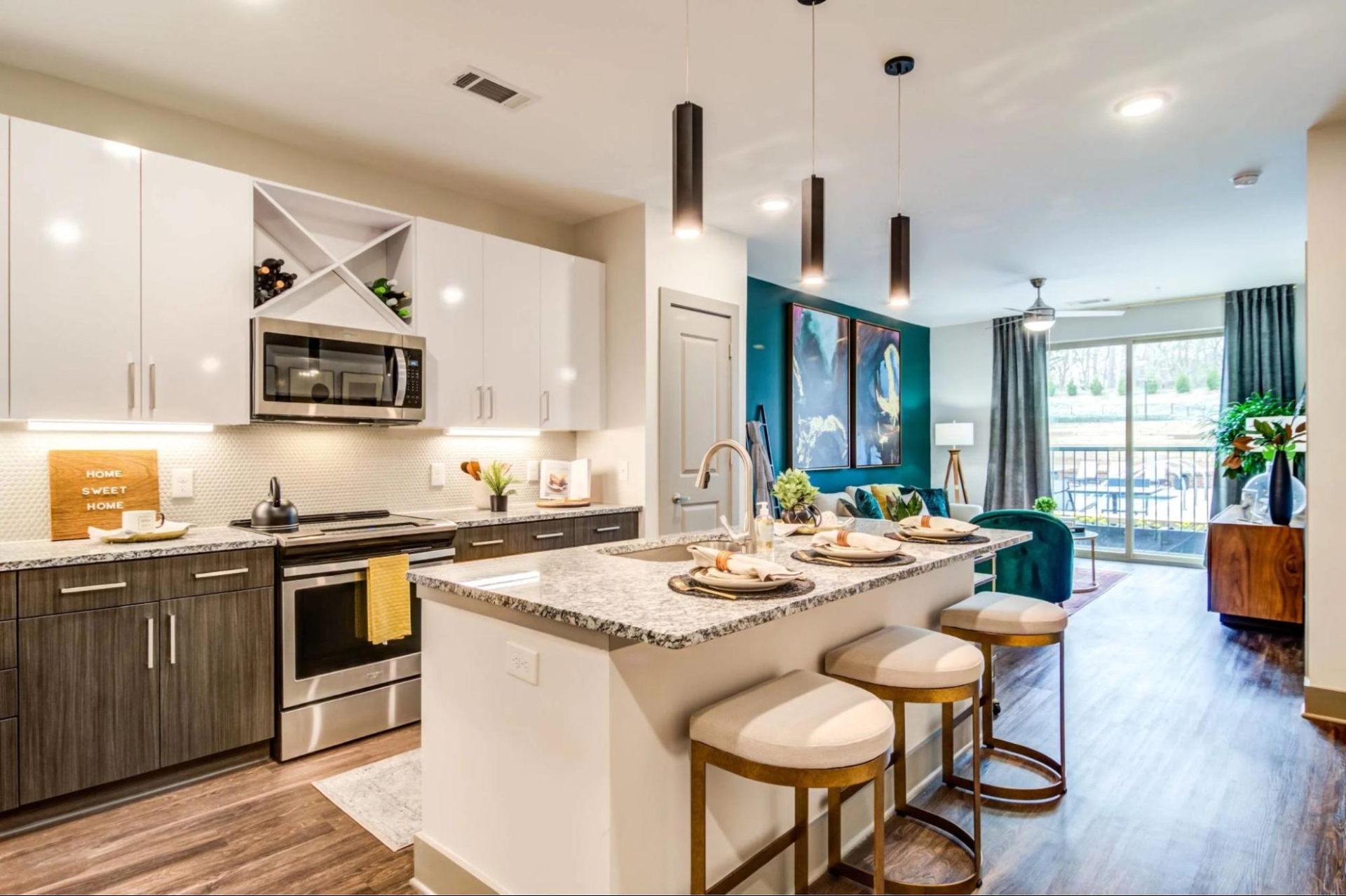 Modern kitchen featuring stainless steel appliances and a stylish bar area in Skye Suwanee Town Center apartment