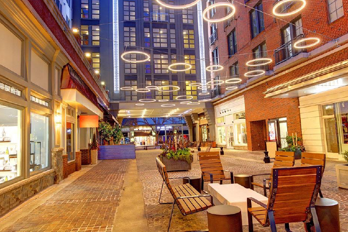 : A pedestrian lane in downtown Bethesda, Maryland at dusk with string lighting and outdoor