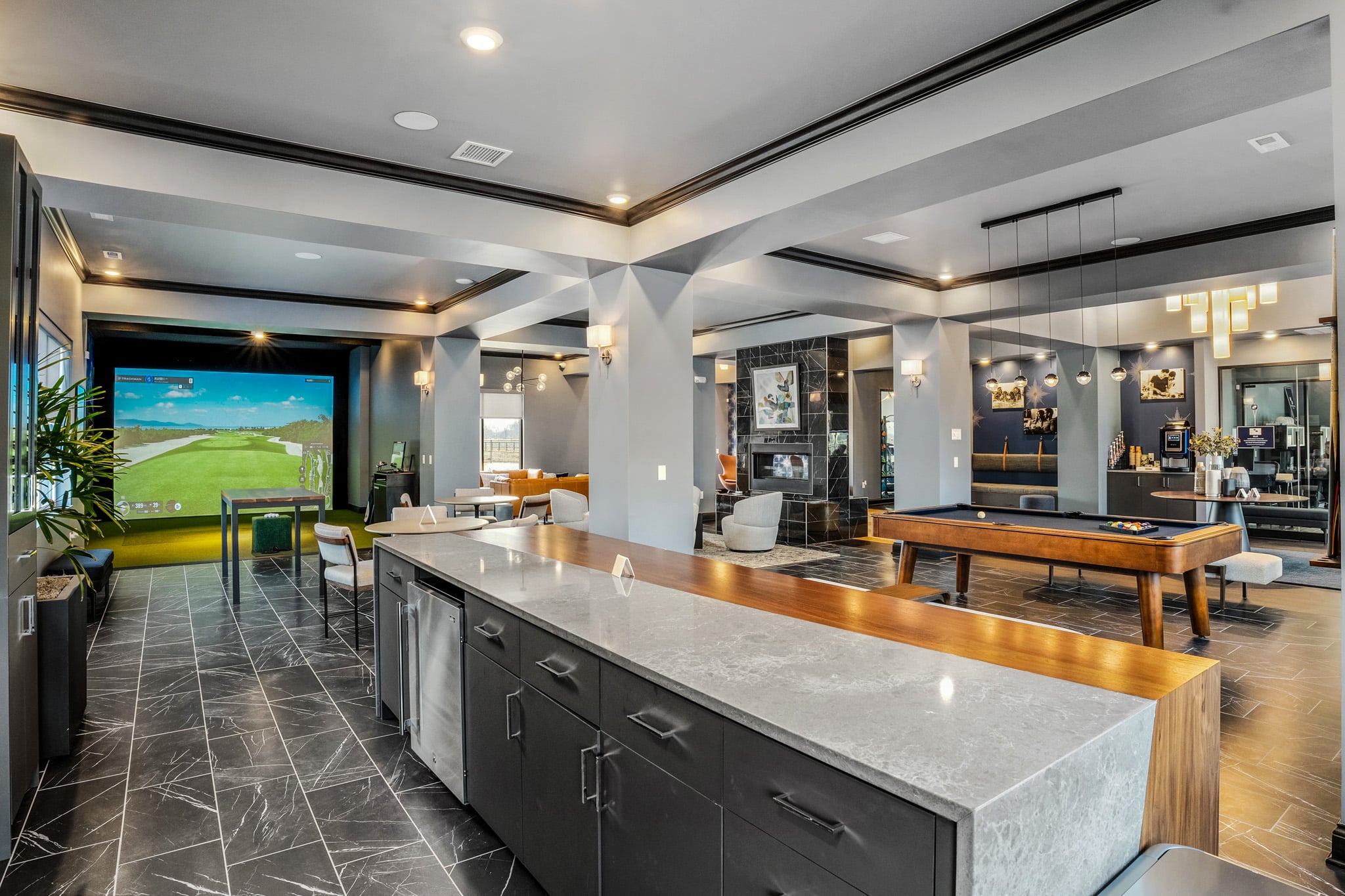 Resident lounge at Northstar Flats in Central Ohio featuring a golf simulator, pool table, and upscale amenities for physician housing.