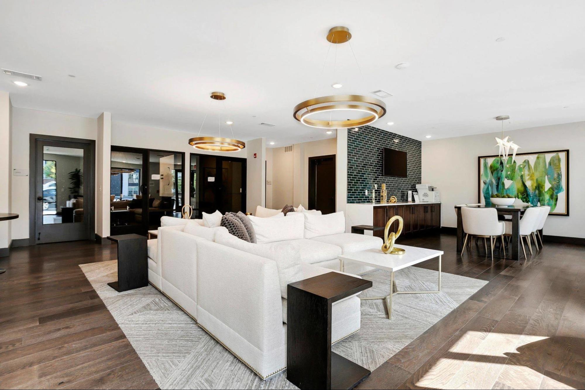 Modern clubroom in Skye Suwanee Town Center apartments featuring hardwood floors and stylish white furniture