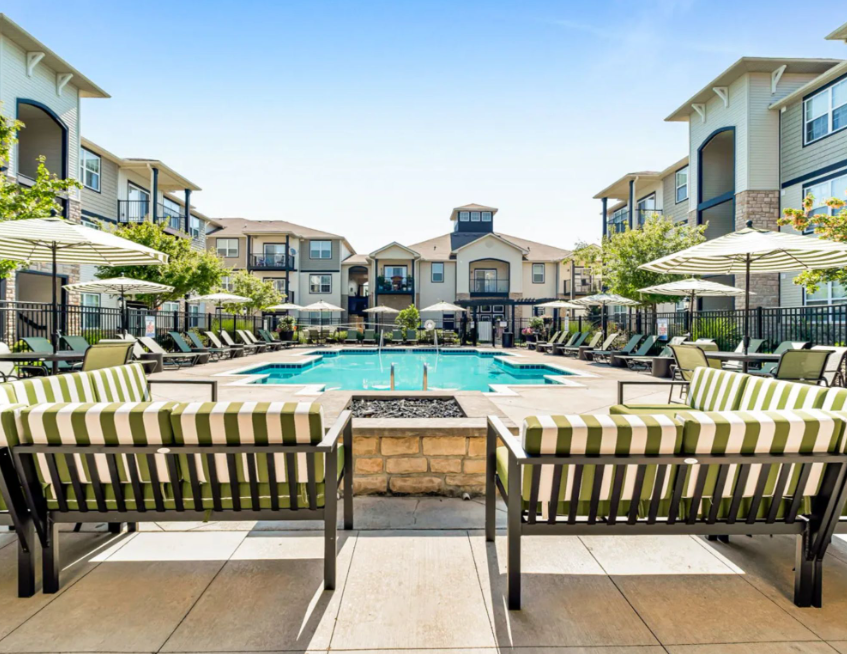 Resort-style swimming pool and sun deck at Gables West apartments with outdoor lounge seating and landscaped courtyard.
