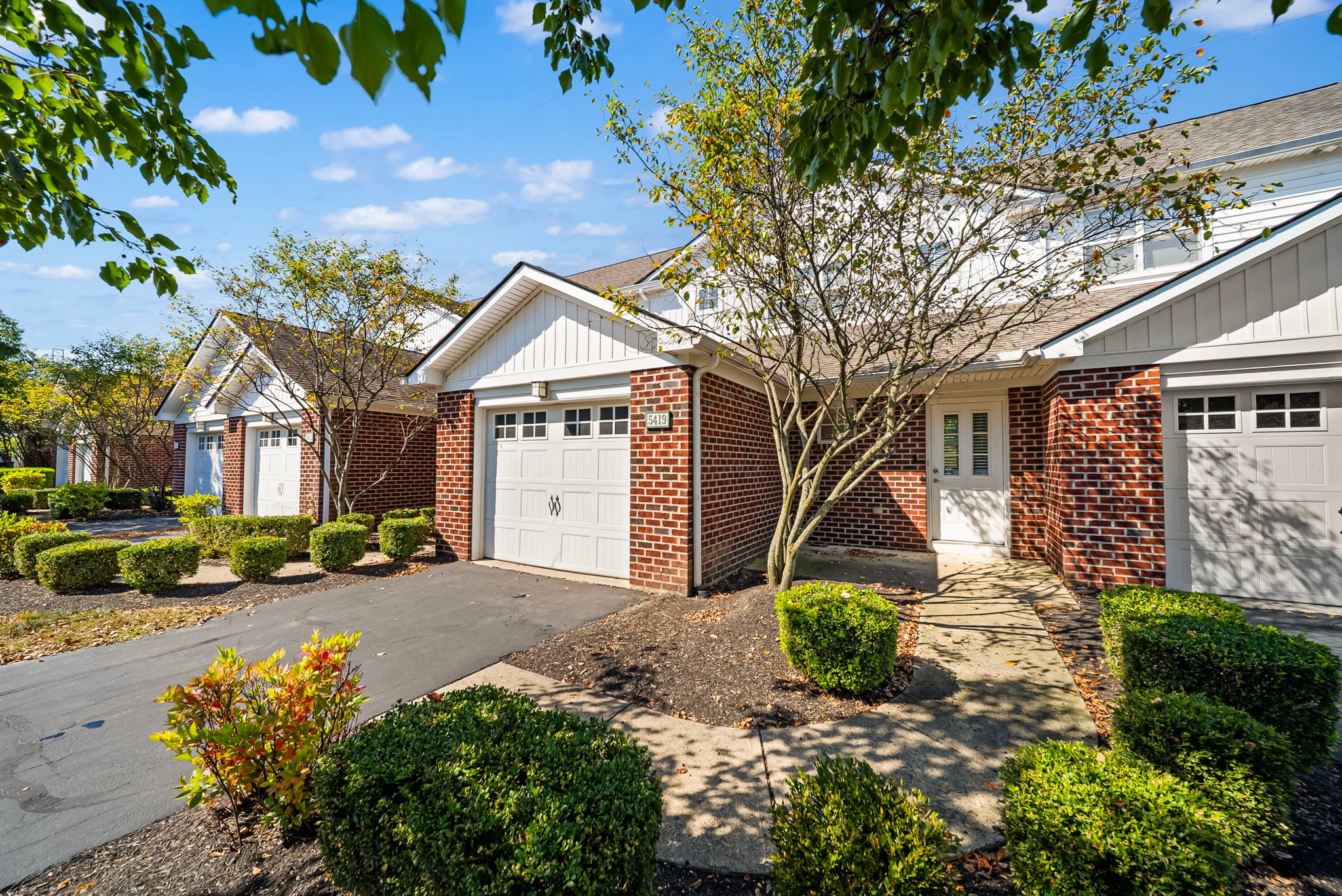  The Glen at Rocky Fork townhomes in New Albany, Ohio featuring attached garages, private entrances, and landscaped walkways.