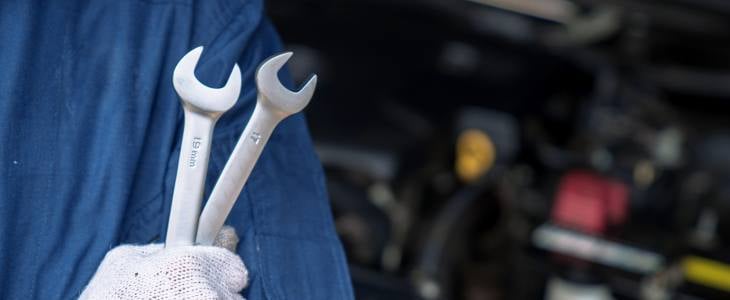 A man holding two wrenches 