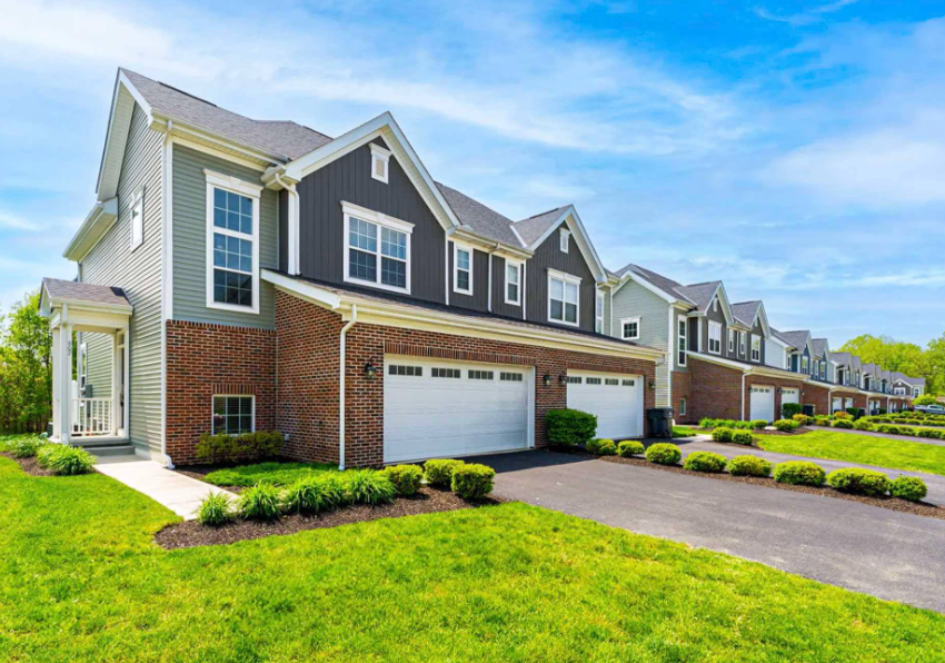 Exterior view of Olentangy Reserve townhomes in Lewis Center, Ohio with attached garages and landscaped grounds.