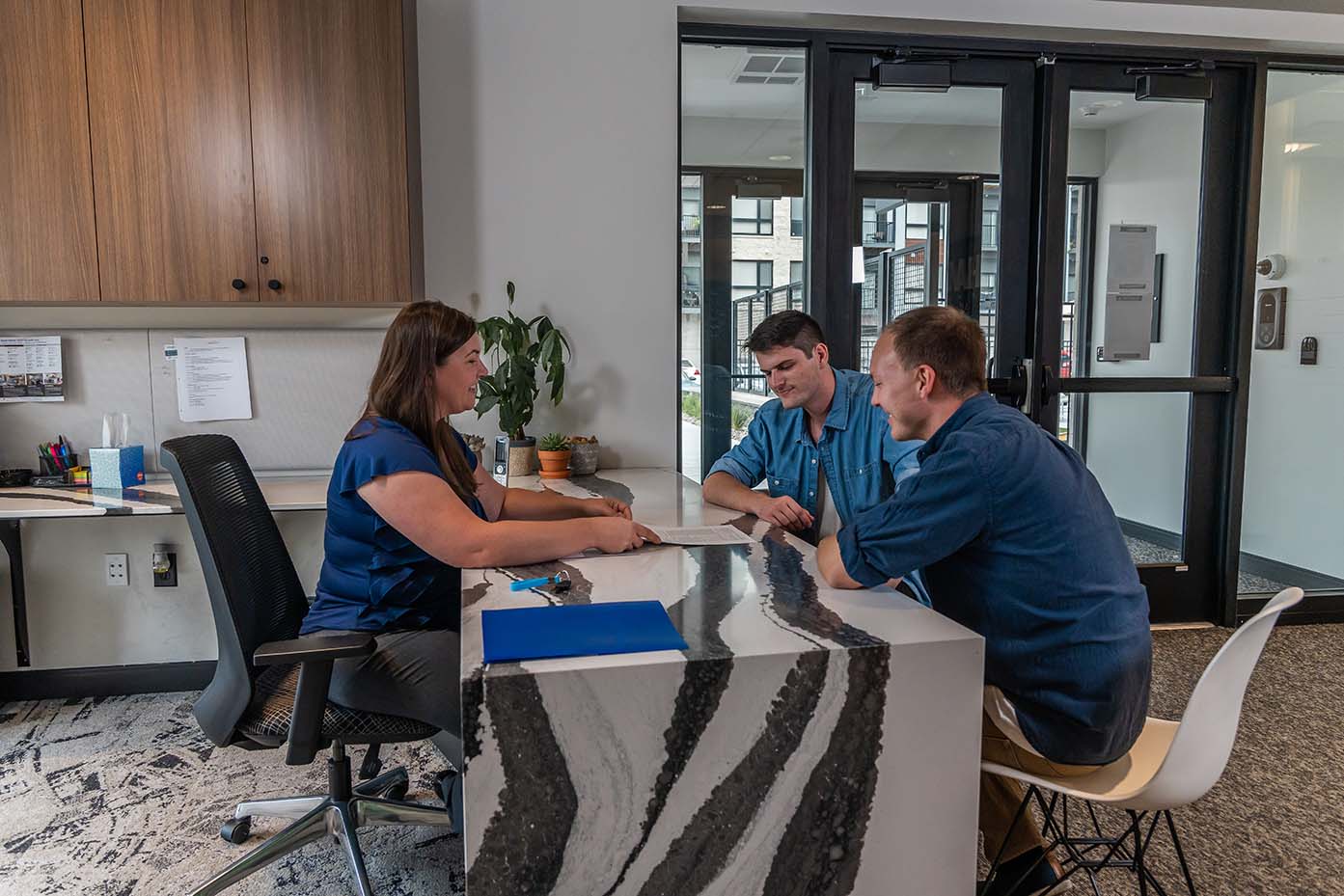 two men meeting with leasing agent at an apartment community
