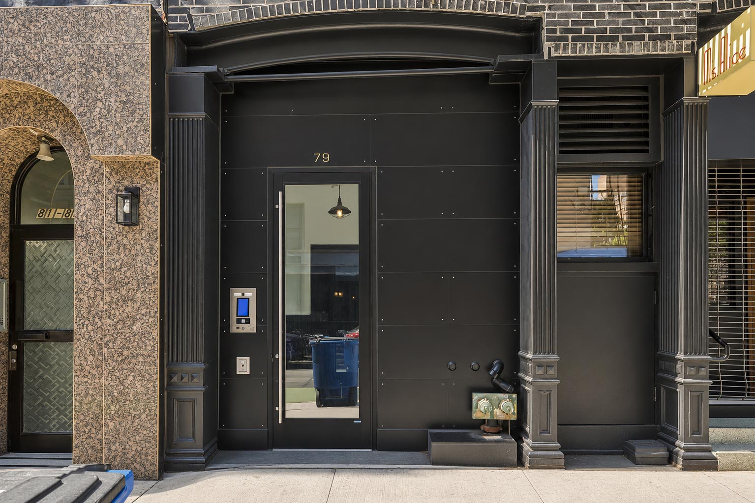 A black door with the number 79 on it.