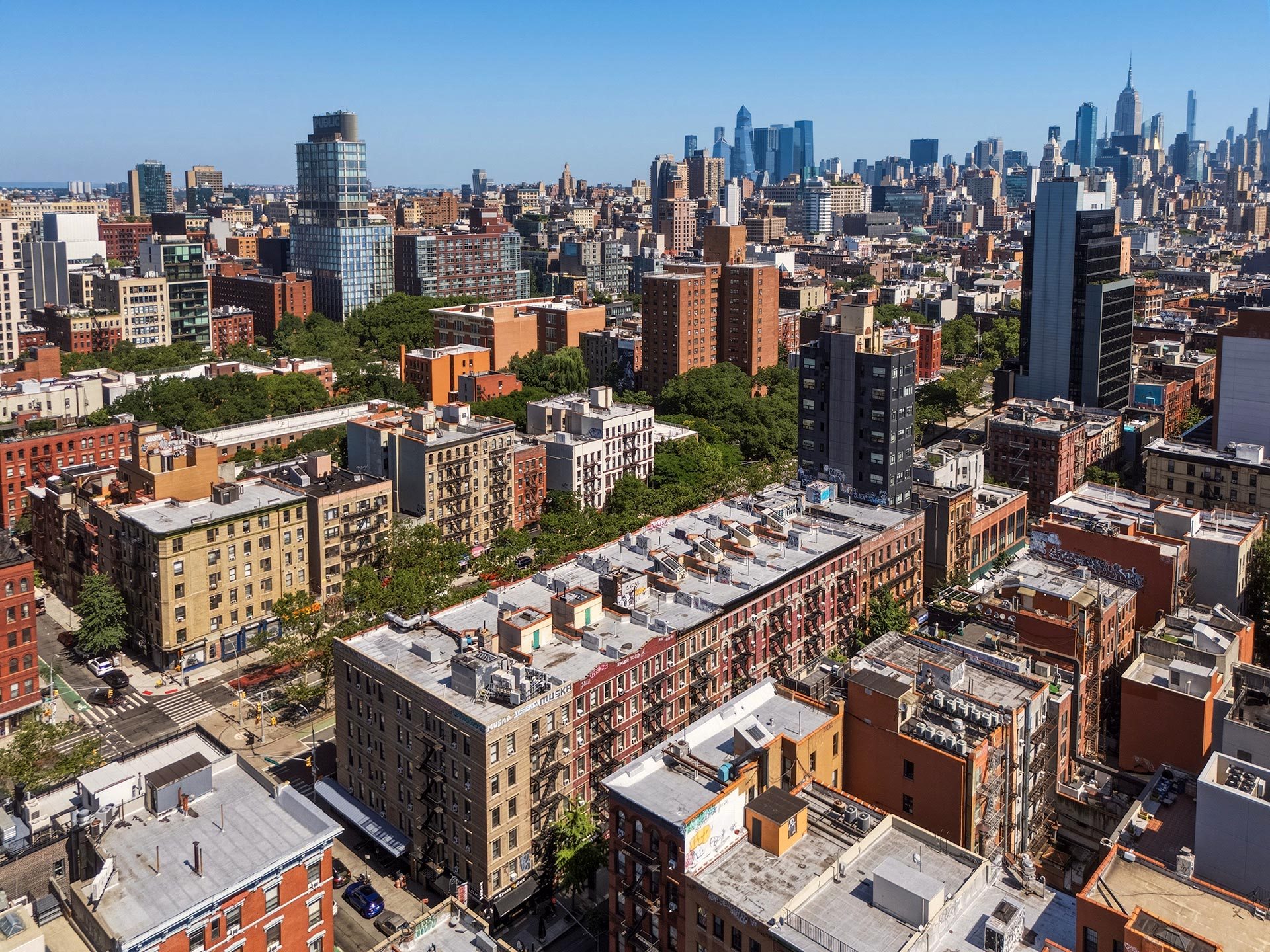 A cityscape with a mix of modern and older buildings under a clear sky.