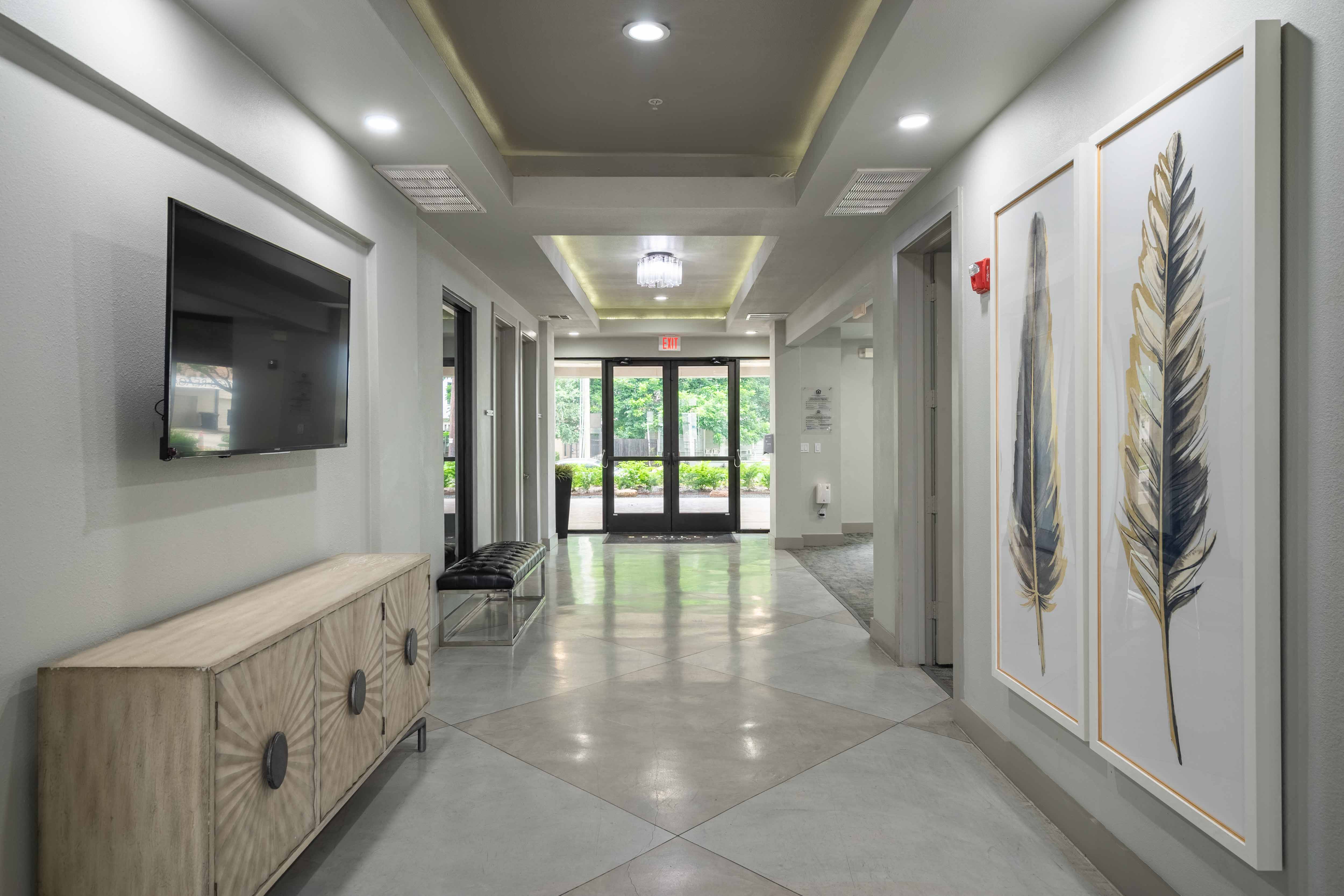 a hallway with a tv and a bench in front of a door