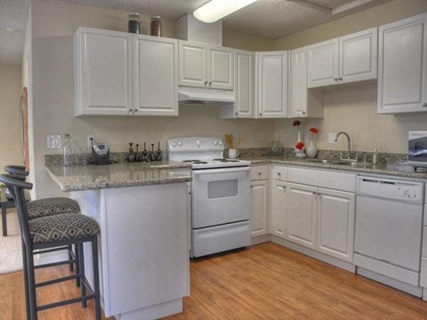 Furnished kitchen model with stove and barstools