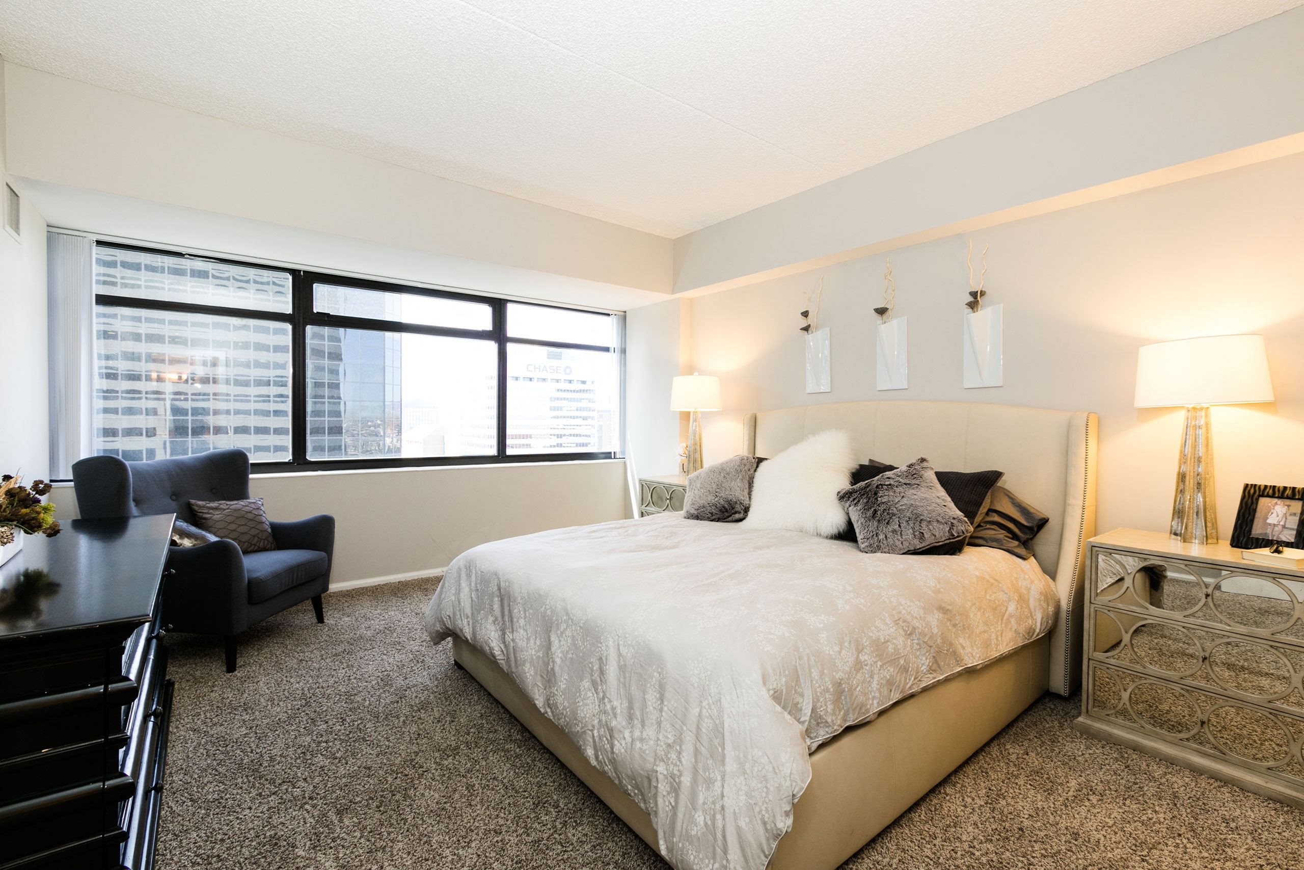 a bedroom with a large bed and a large window at Apartments at Denver Place, Denver