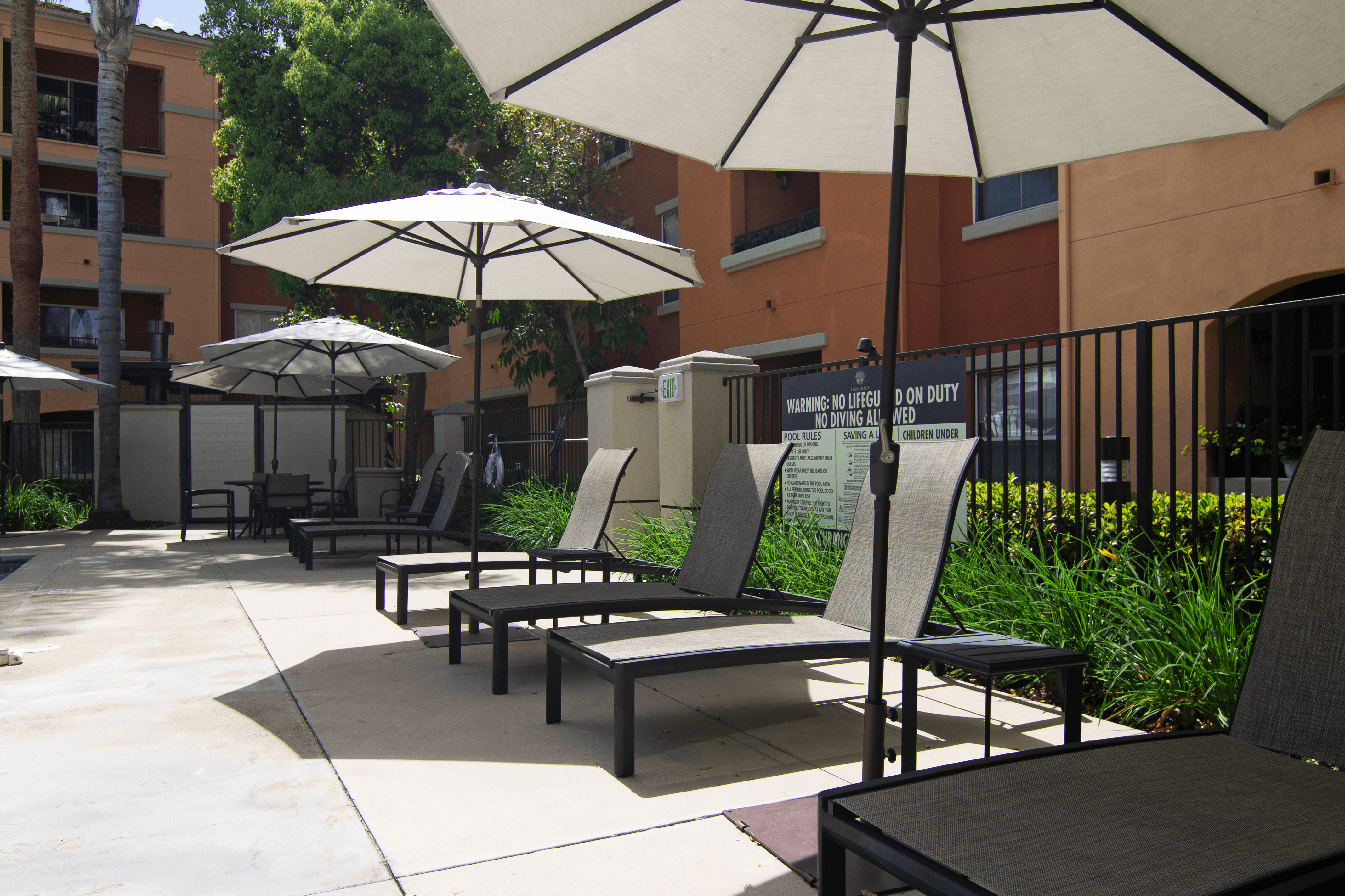 A patio with chairs and umbrellas.
