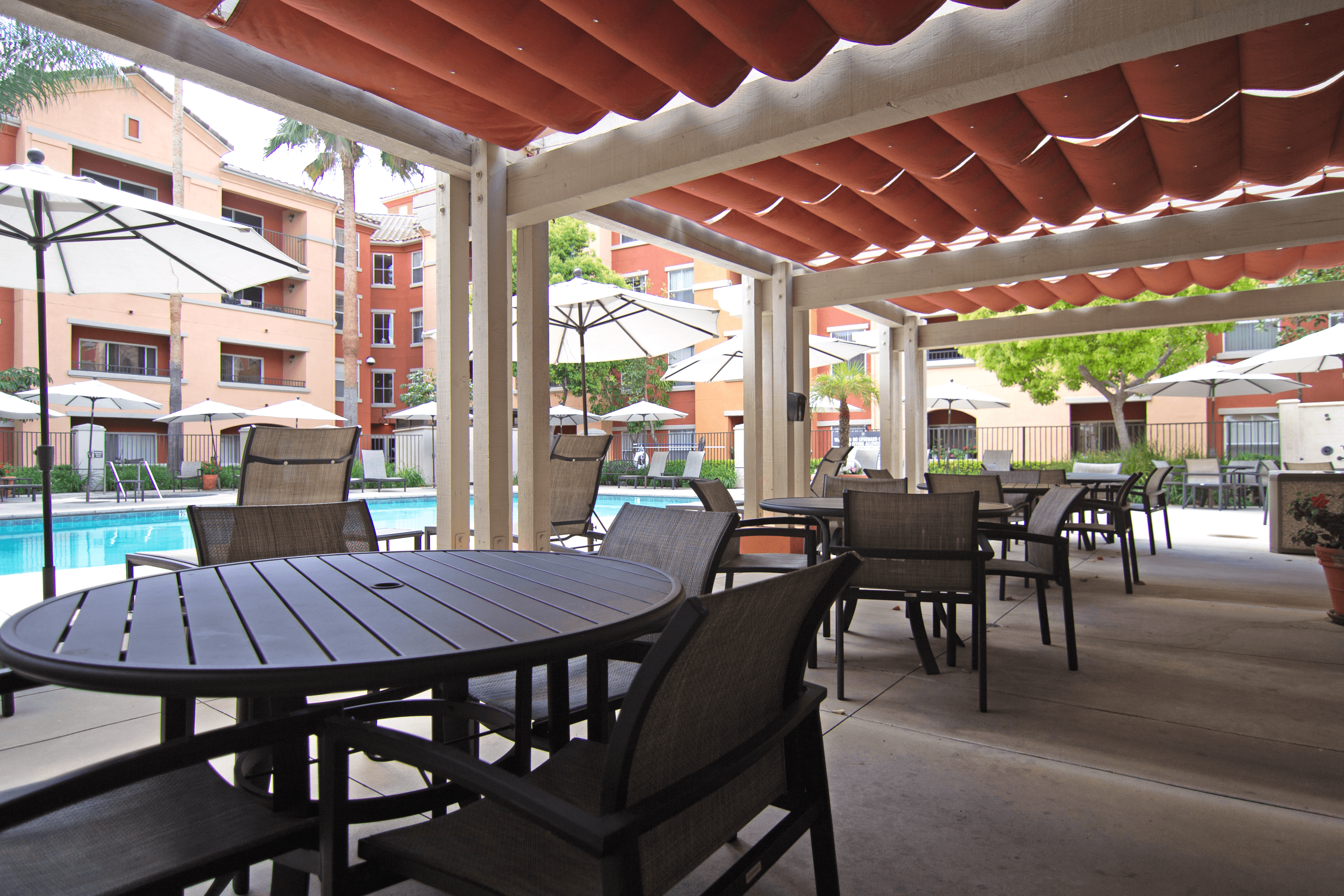 A patio with a table and chairs under a roof.
