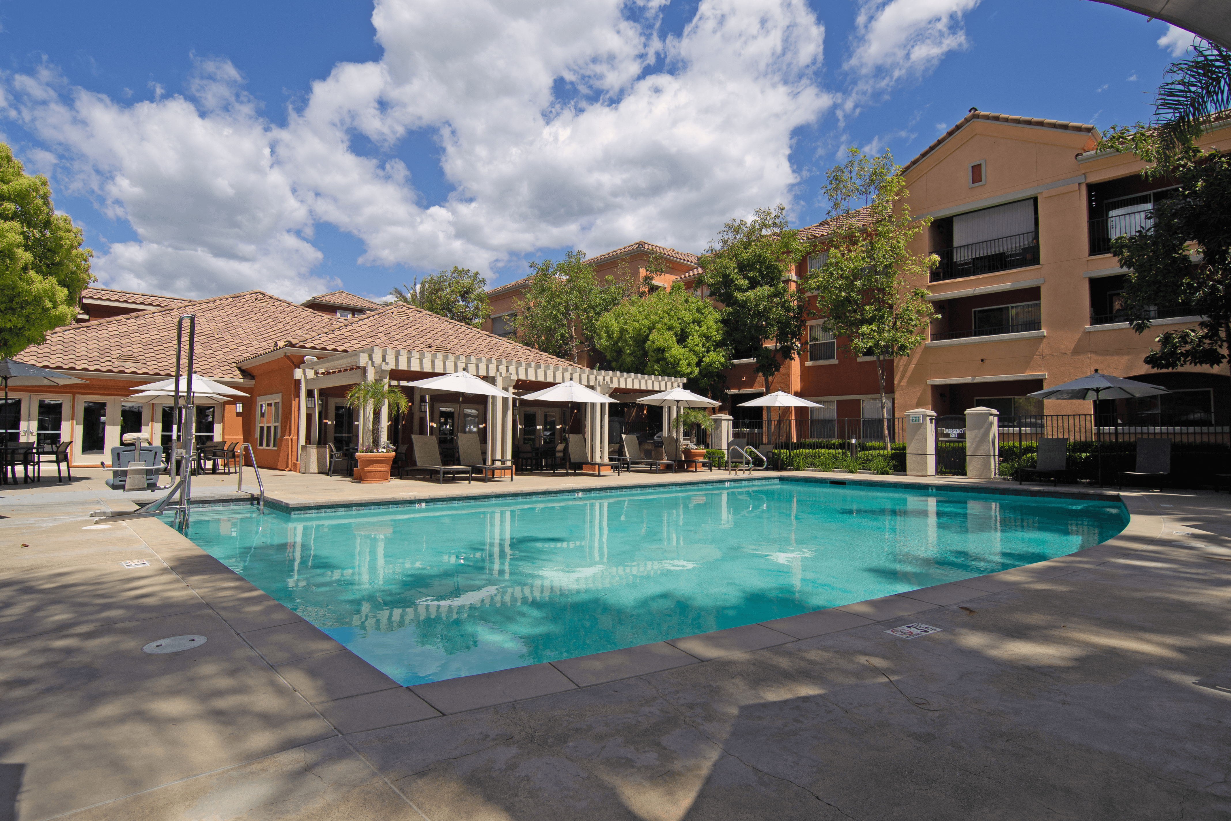 A large swimming pool surrounded by buildings and trees.