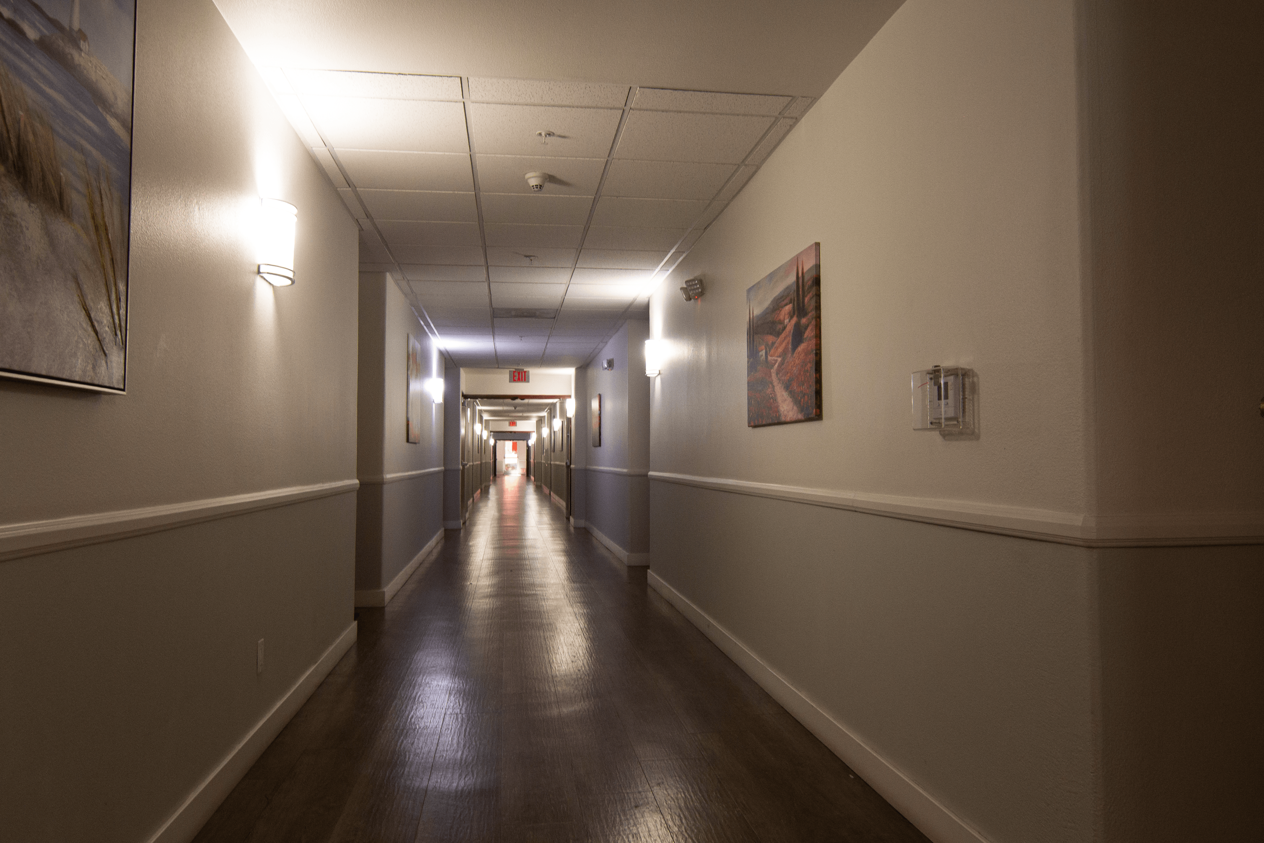 A long hallway with lights on the ceiling and walls.
